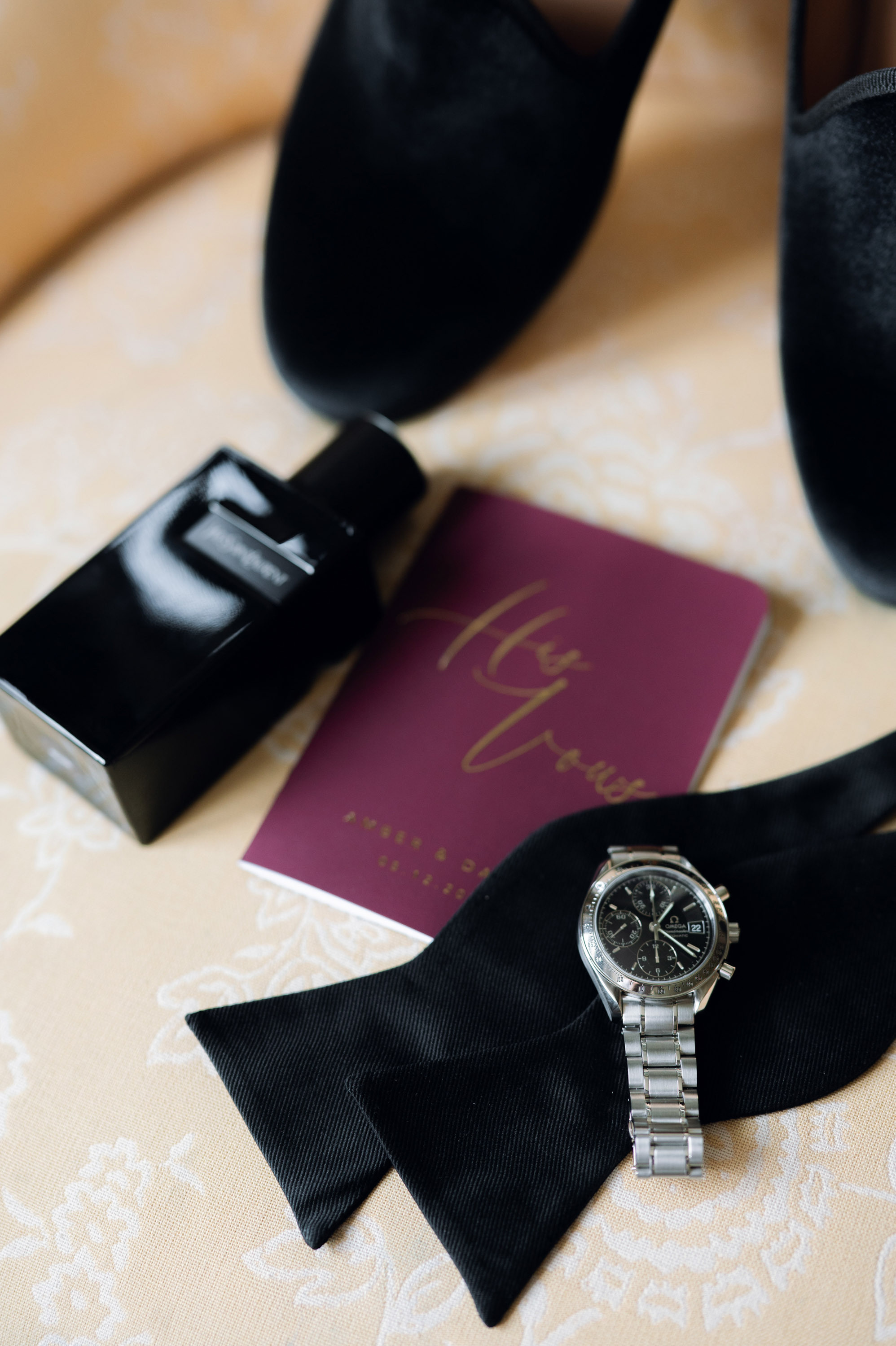 a pair of shoes and a watch on a bed