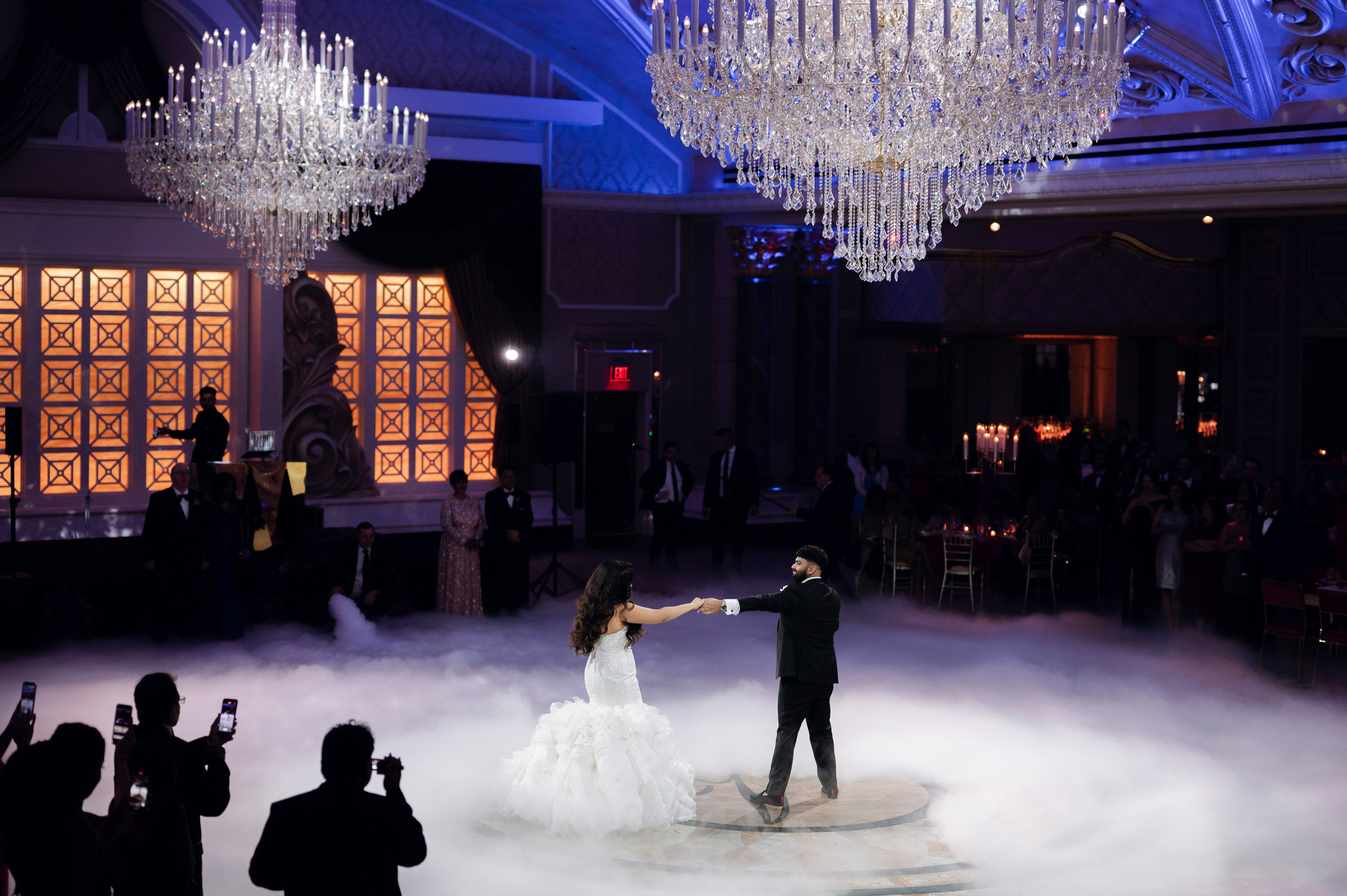 a bride and groom dancing in a cloud filled ballroom