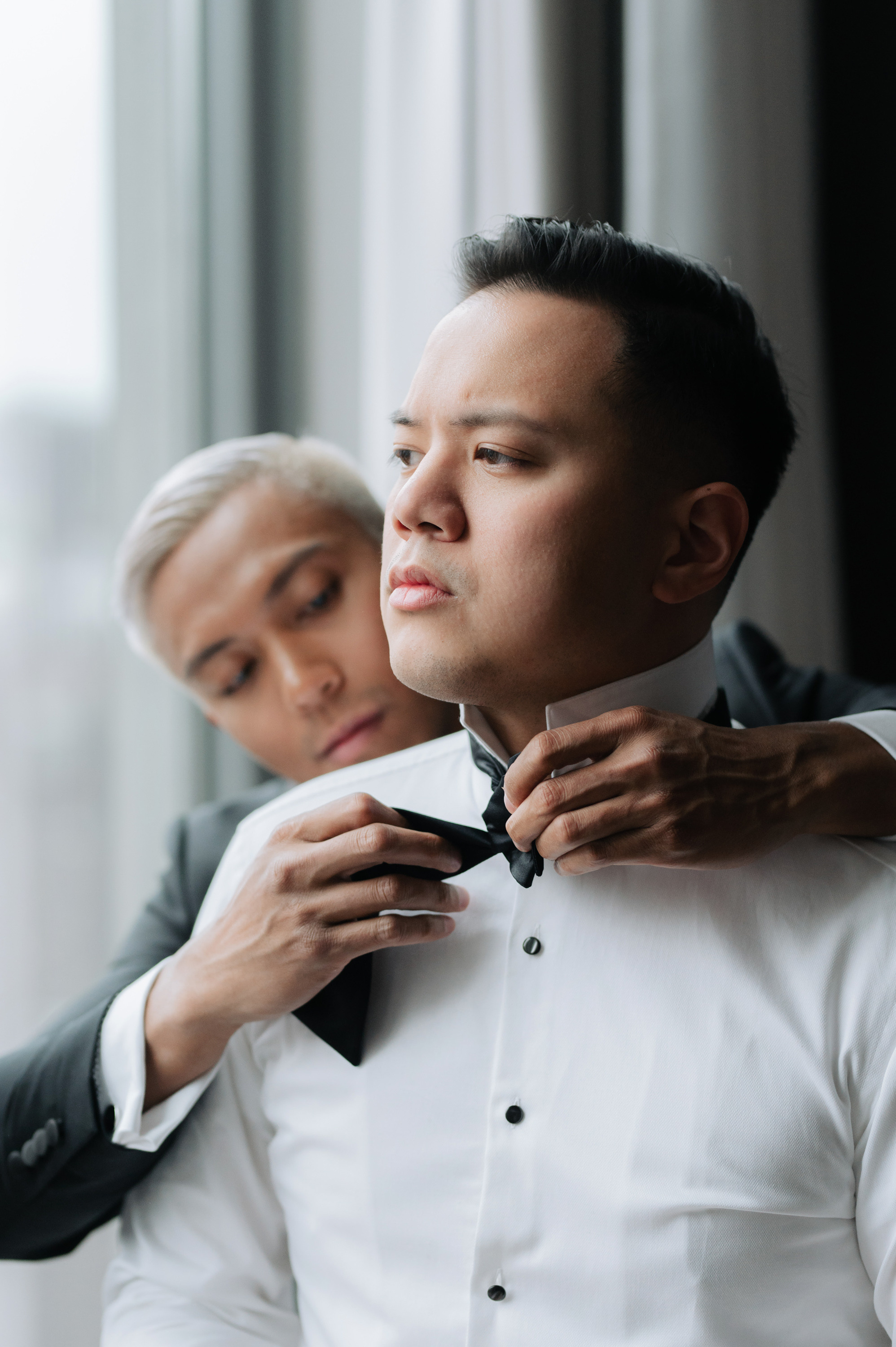 a man in a suit adjusting his tie