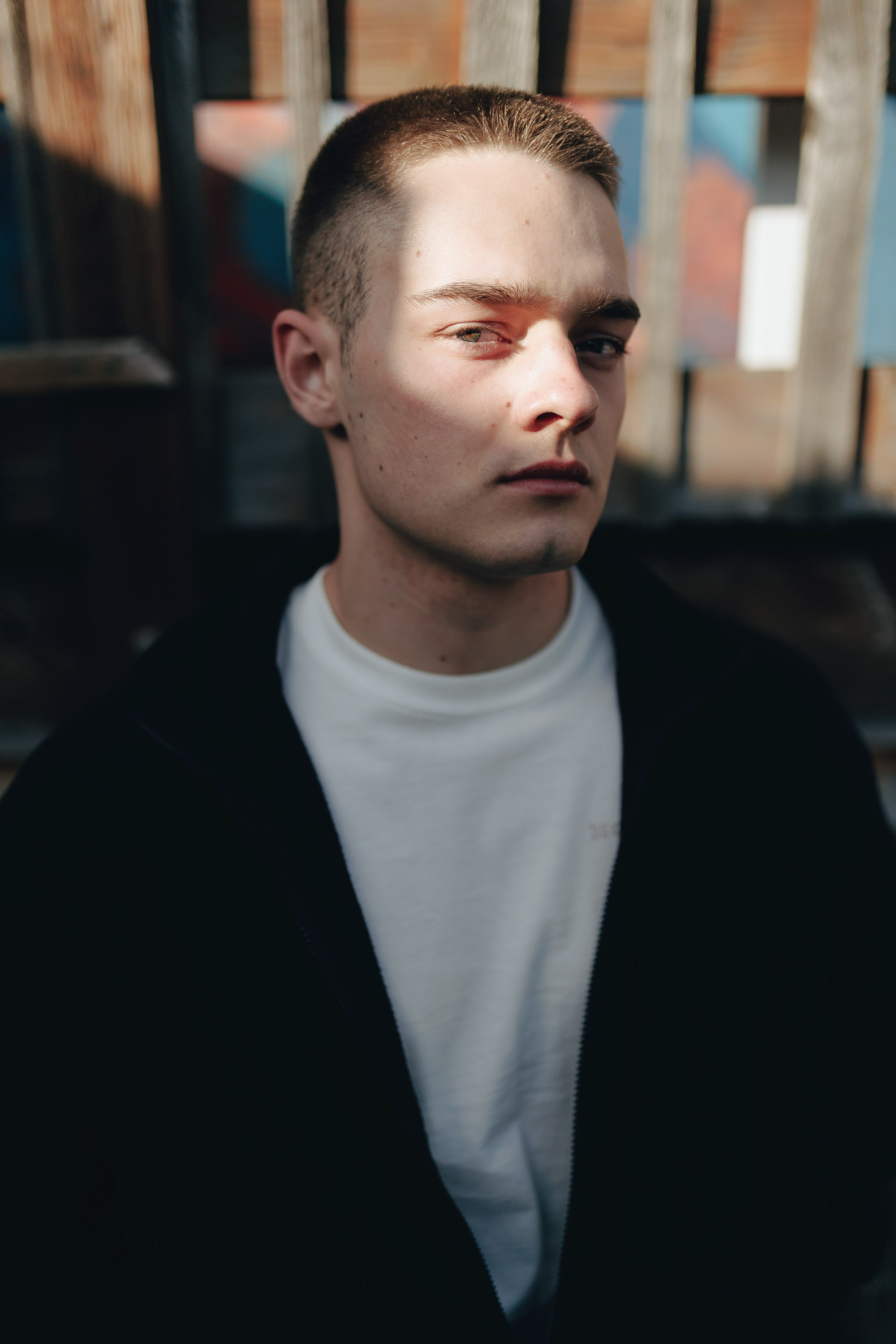 Young man with short haircut in black coat