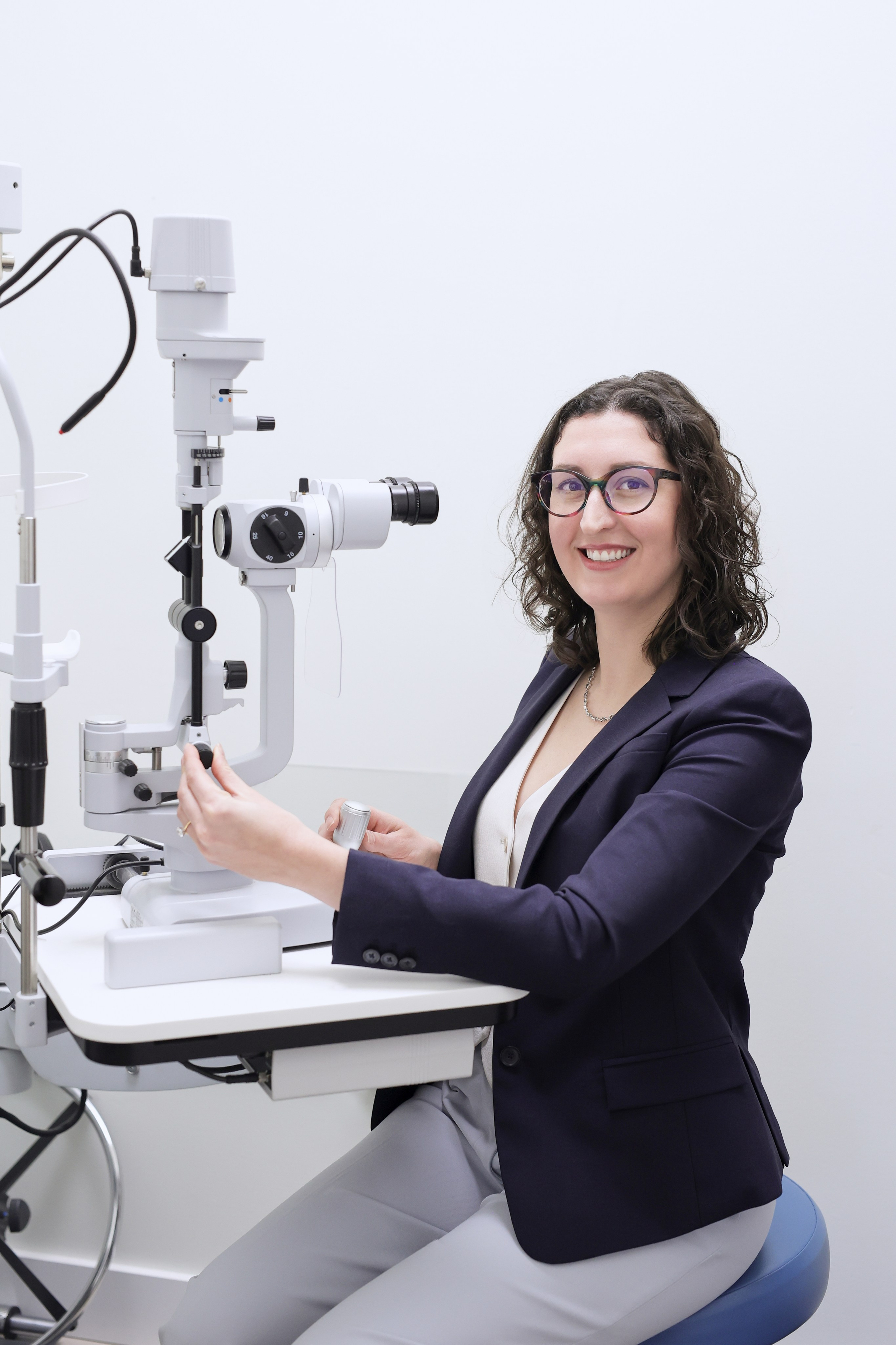 headshot of female optometrist in office behind machine 