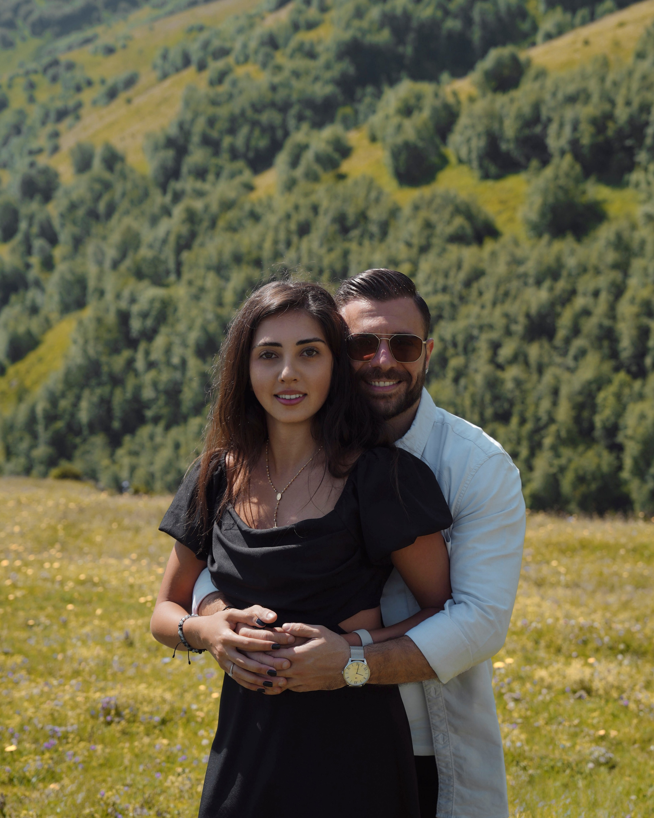 Couple portrait in mountains with green hills background