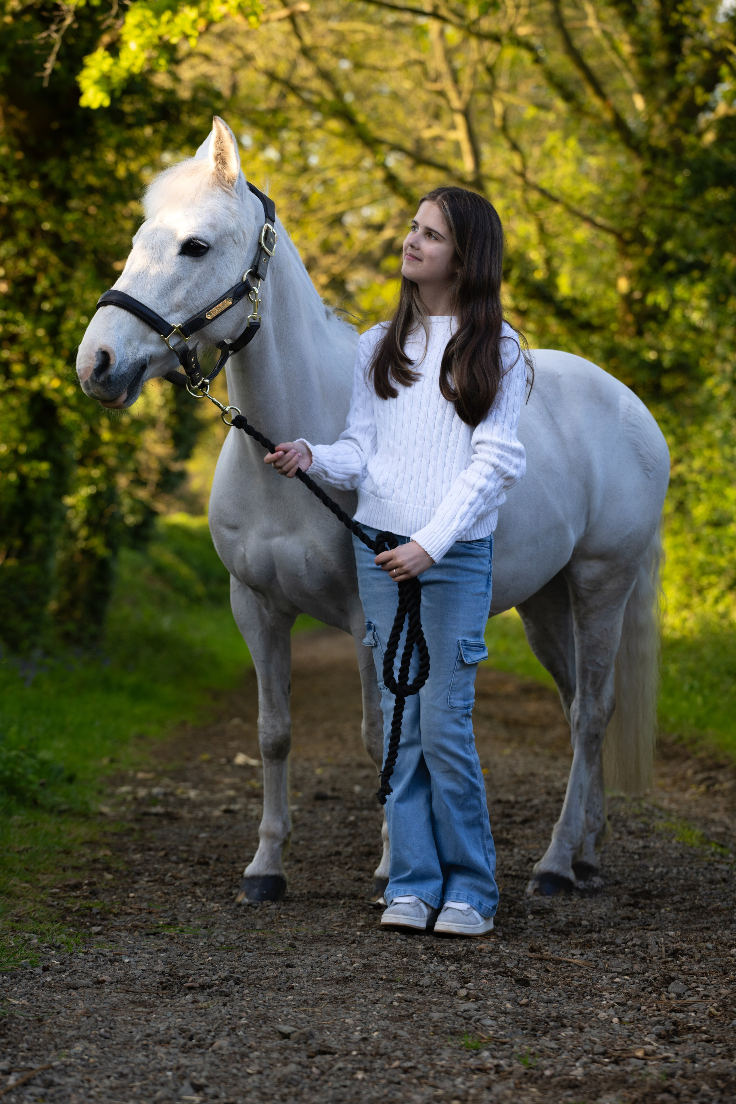 Natural interaction between teenage girl and her horse in open pasture