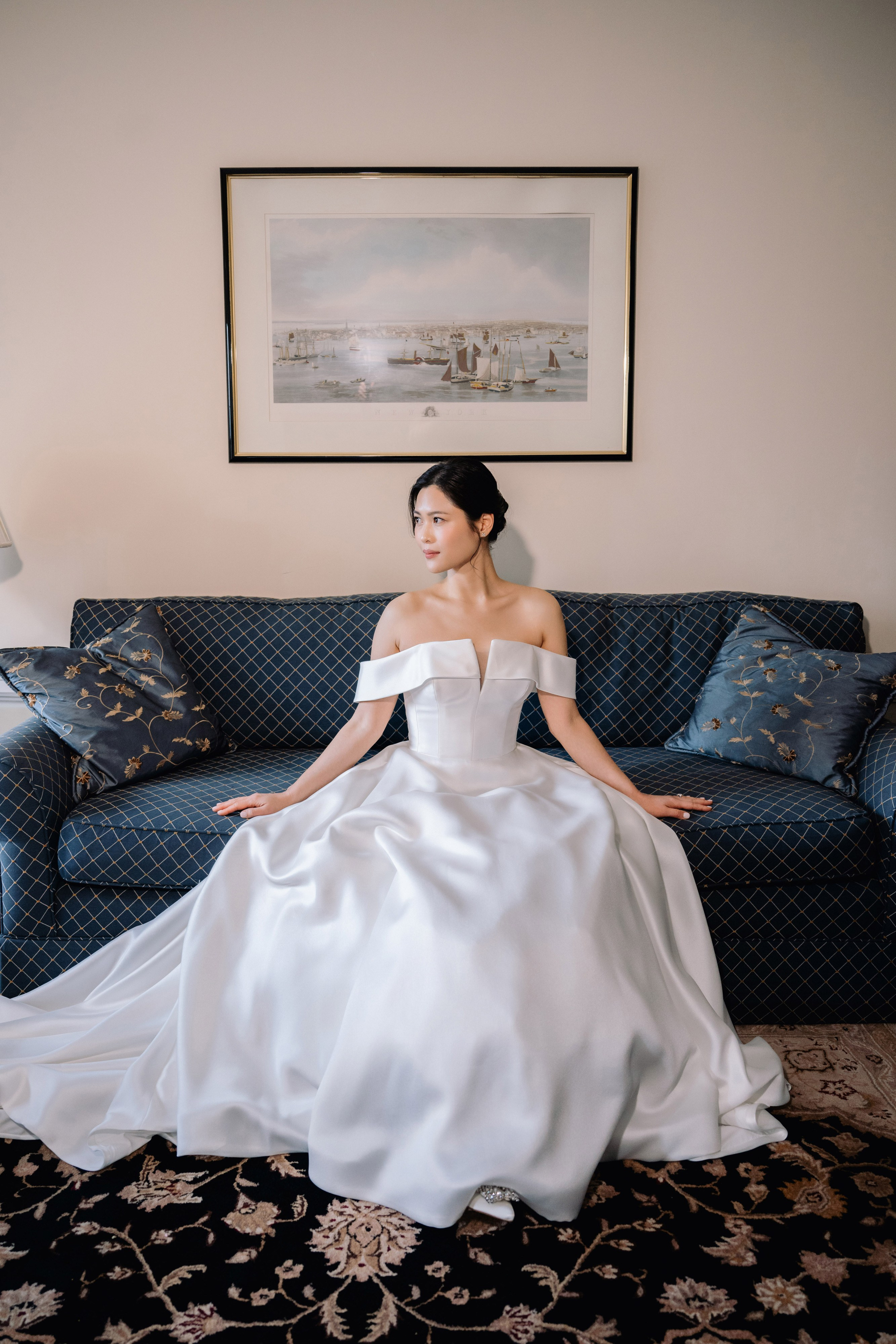 a woman in a white dress sitting on a couch