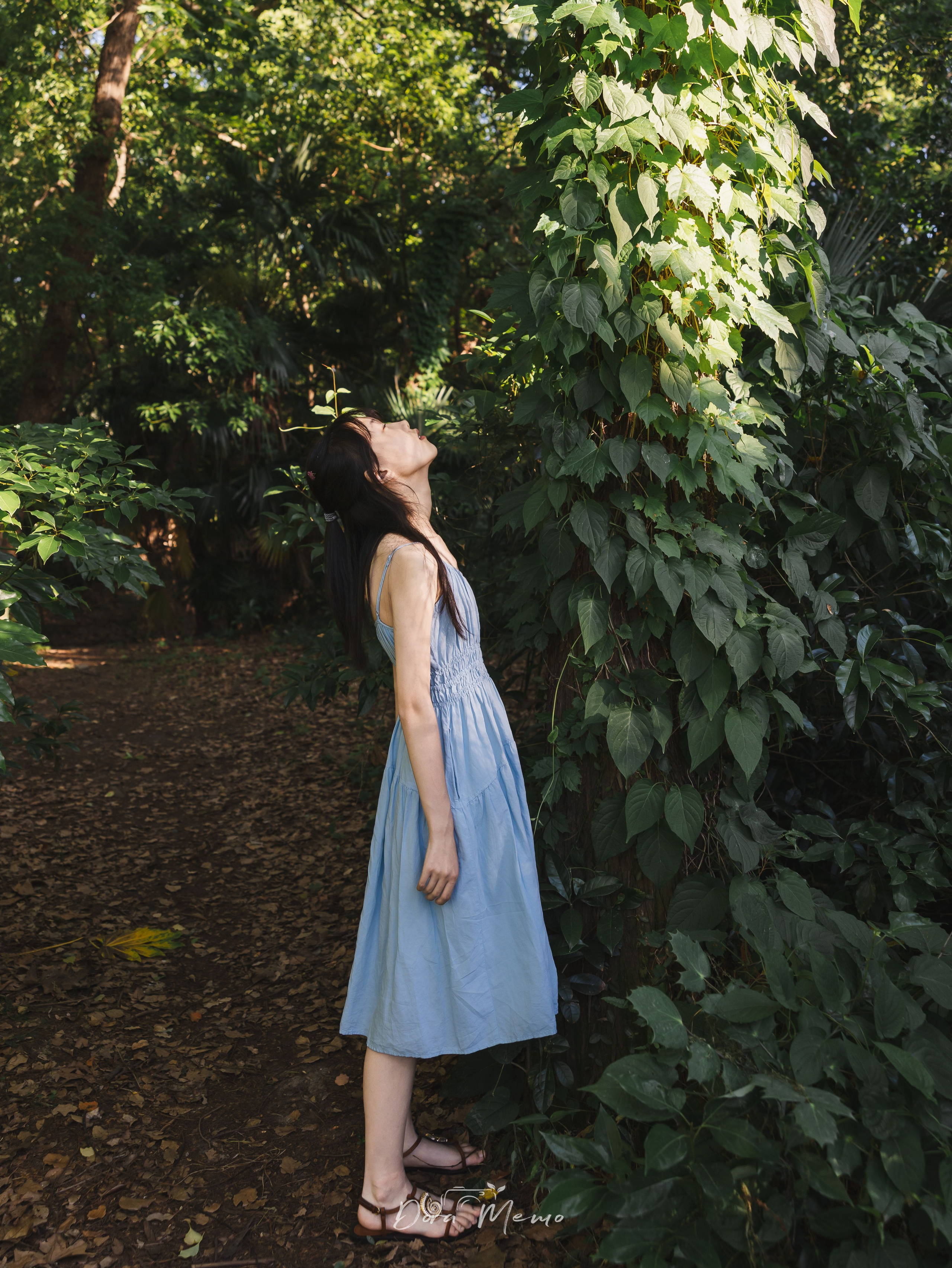 Standing among trees, eyes closed, side light | A teenage girl standing quietly in a Shanghai forest, sunlight filtering through the leaves 