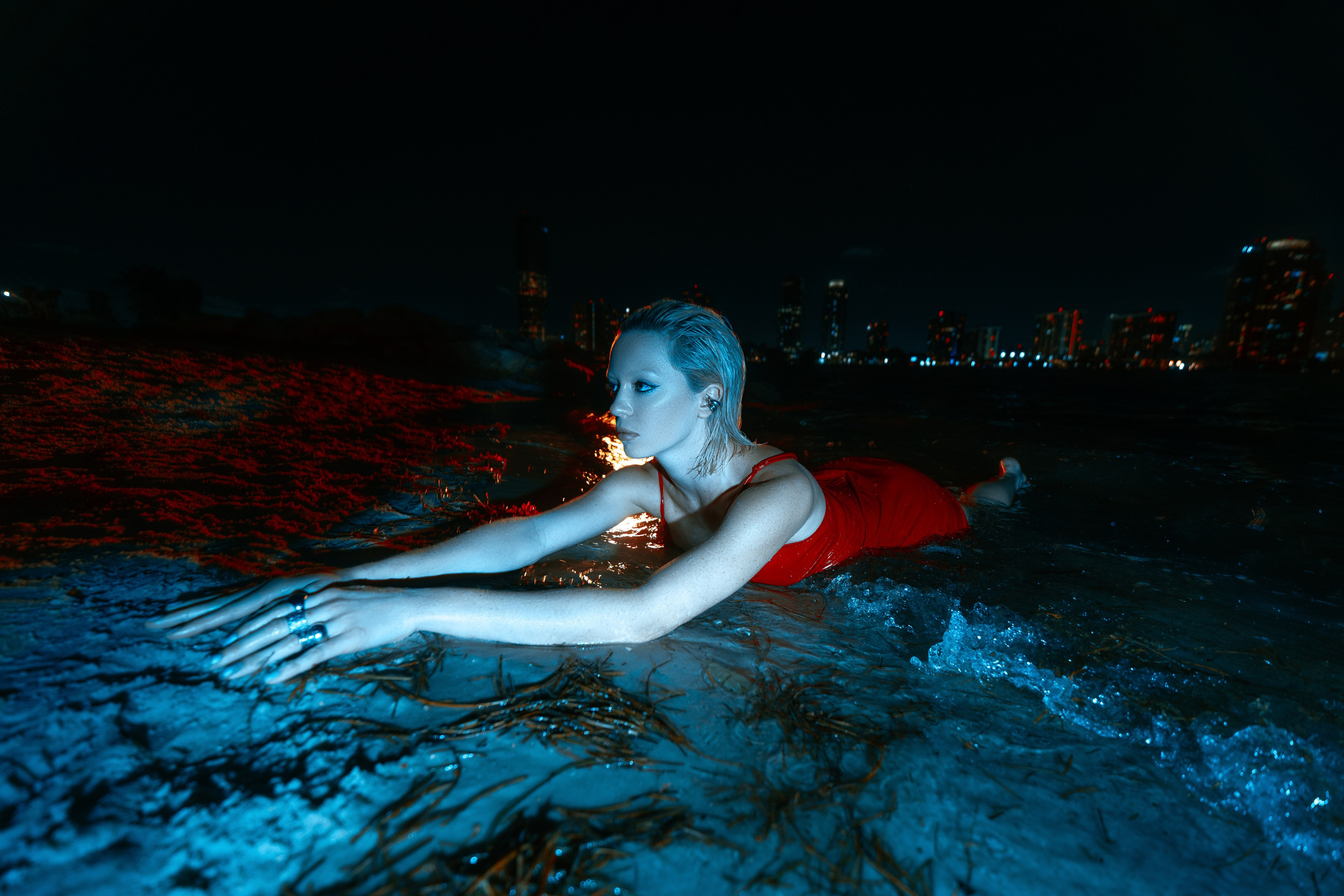 Reclining pose in the sand, the red dress enhancing body lines. Light adds dimensional depth.
