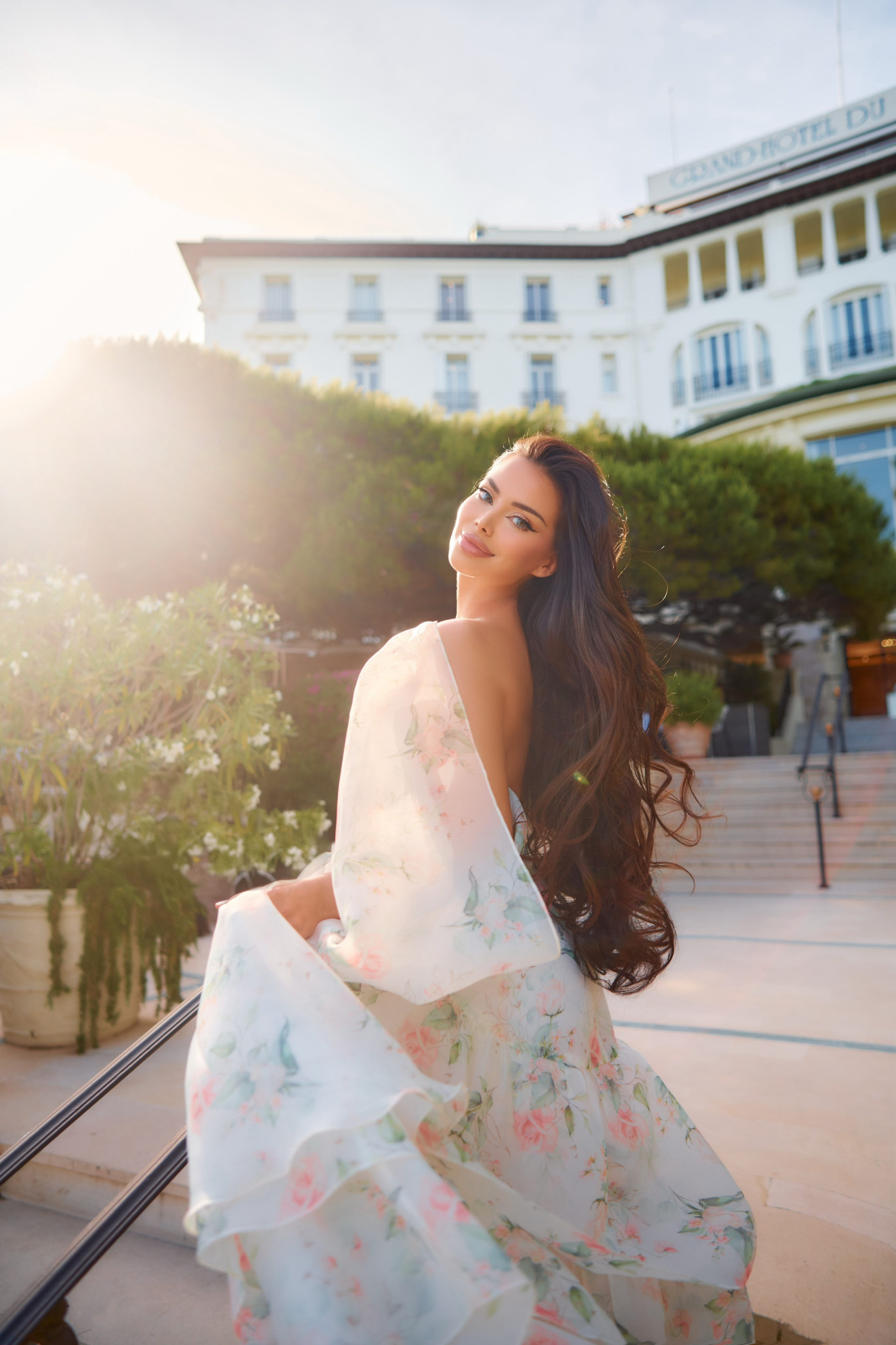 Outdoor fashion photography of model in organza dress with hotel architecture background