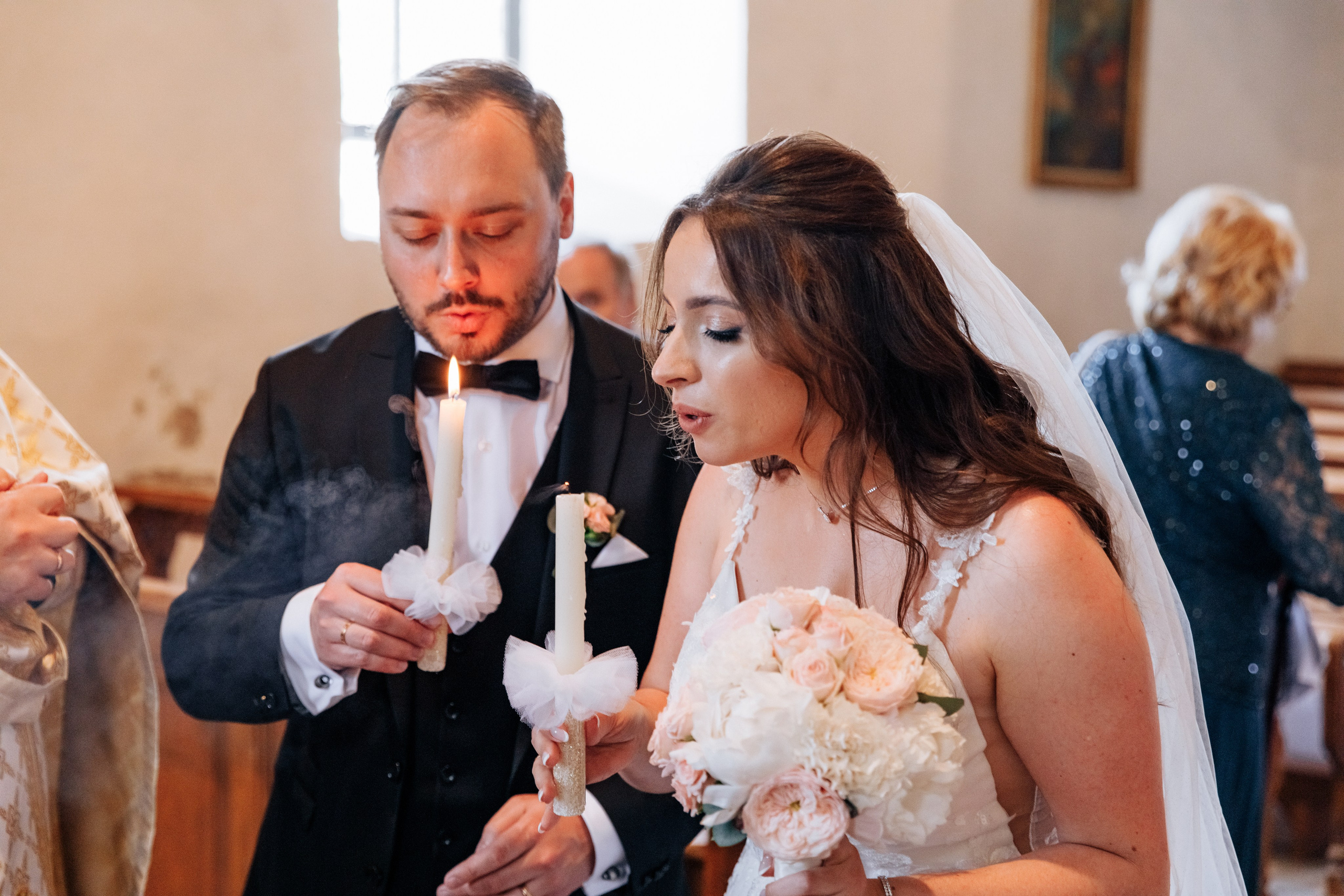 Braut und Bräutigam pusten gemeinsam die Kerzen während der Hochzeitszeremonie aus.