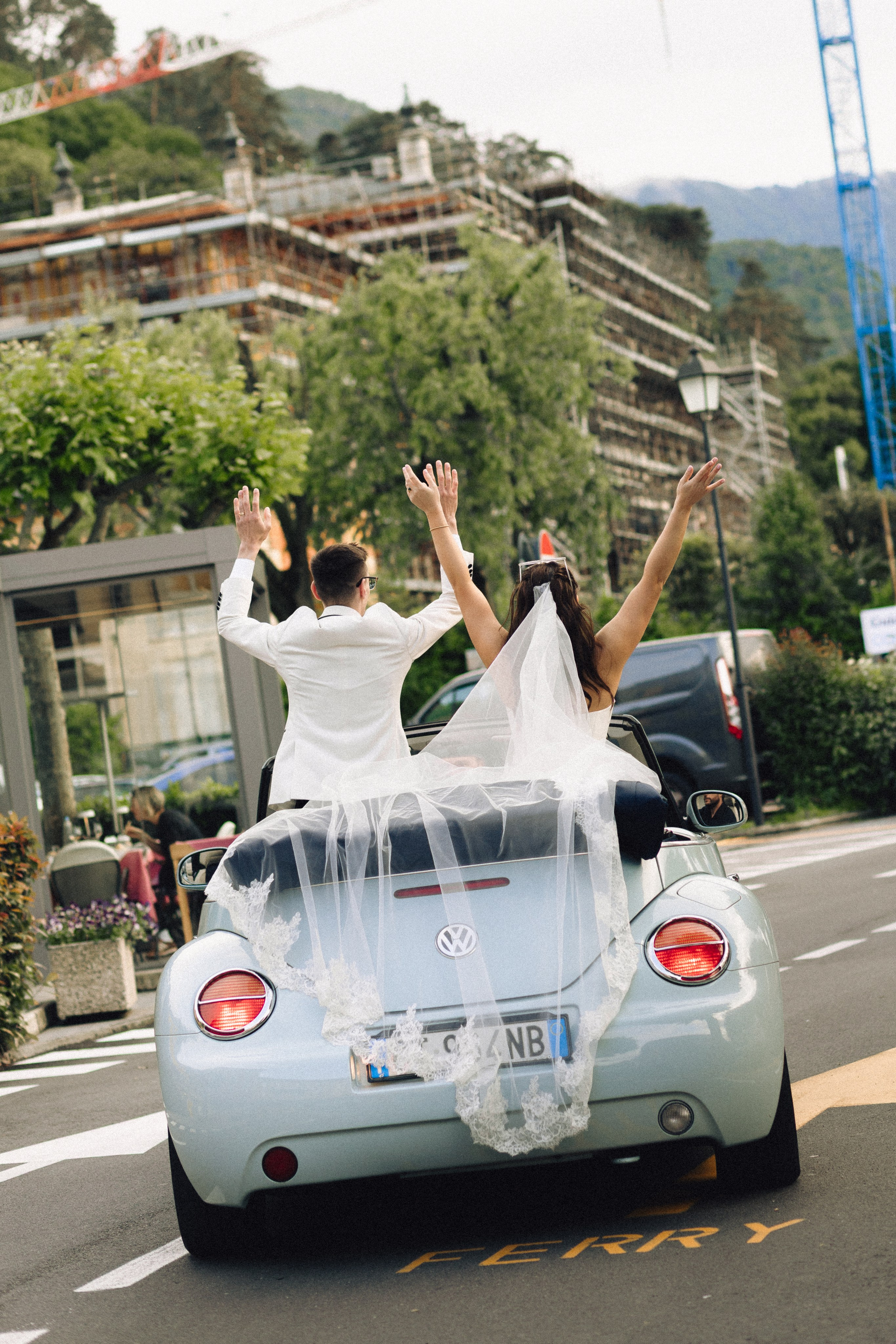 Newlyweds driving through Bellagio in a blue convertible after their intimate wedding