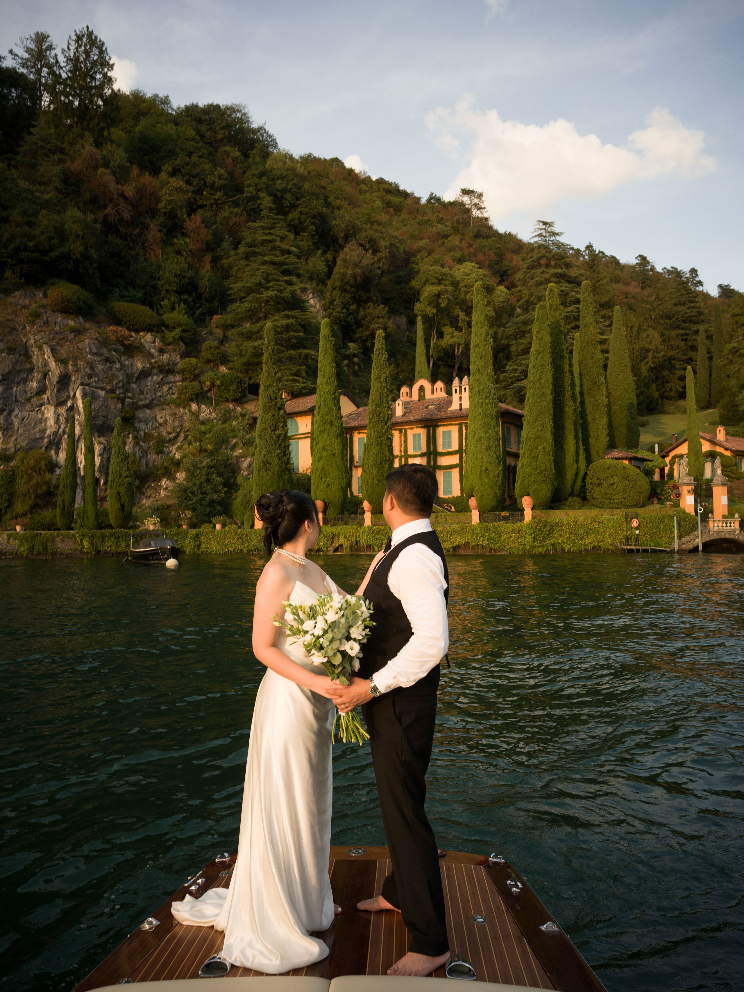 Villa La Cassinella Lake Como elopement with a couple on a traditional boat in front of the historic villa