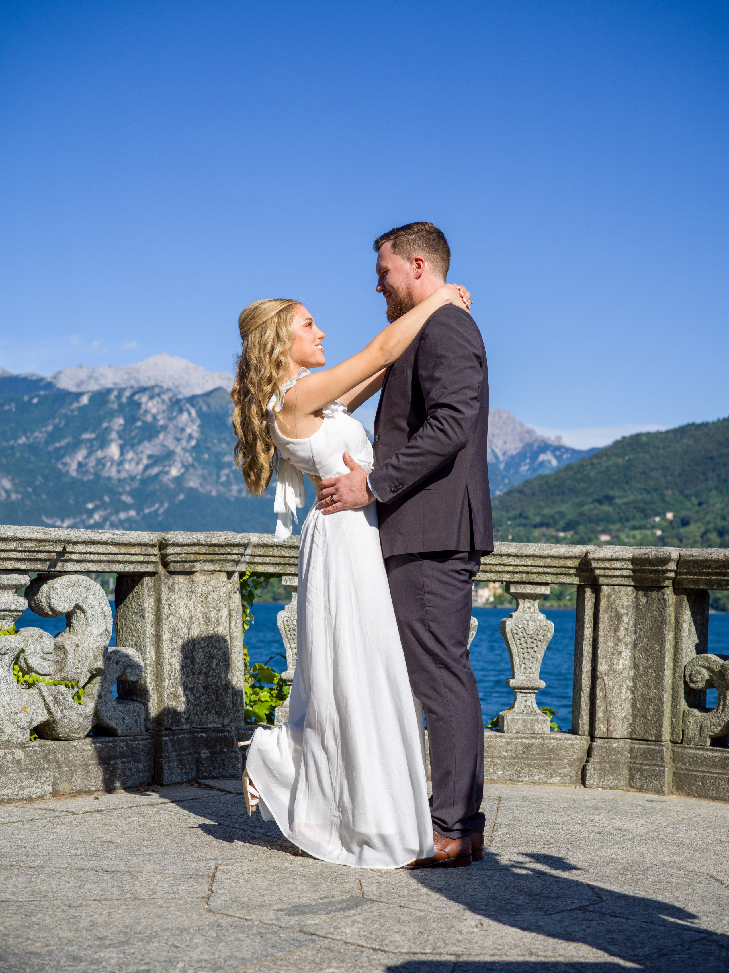 Cinematic couple portrait by Lake Como shoreline at Parco Civico Teresio Olivelli, Tremezzo, Italy