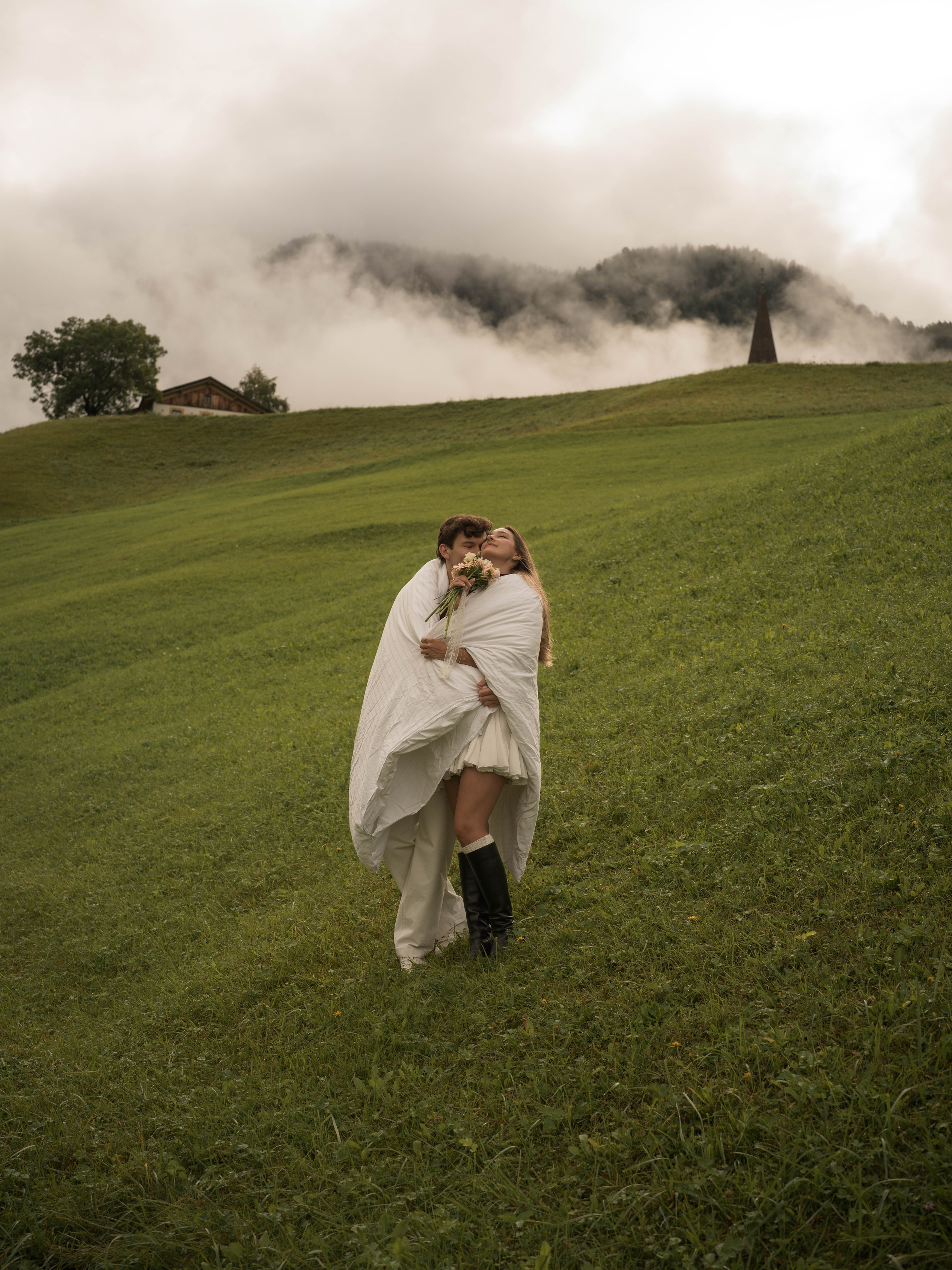 Romantic couple photoshoot after a surprise proposal in Santa Maddalena, Dolomites, with cinematic mountain scenery and natural emotional photography.