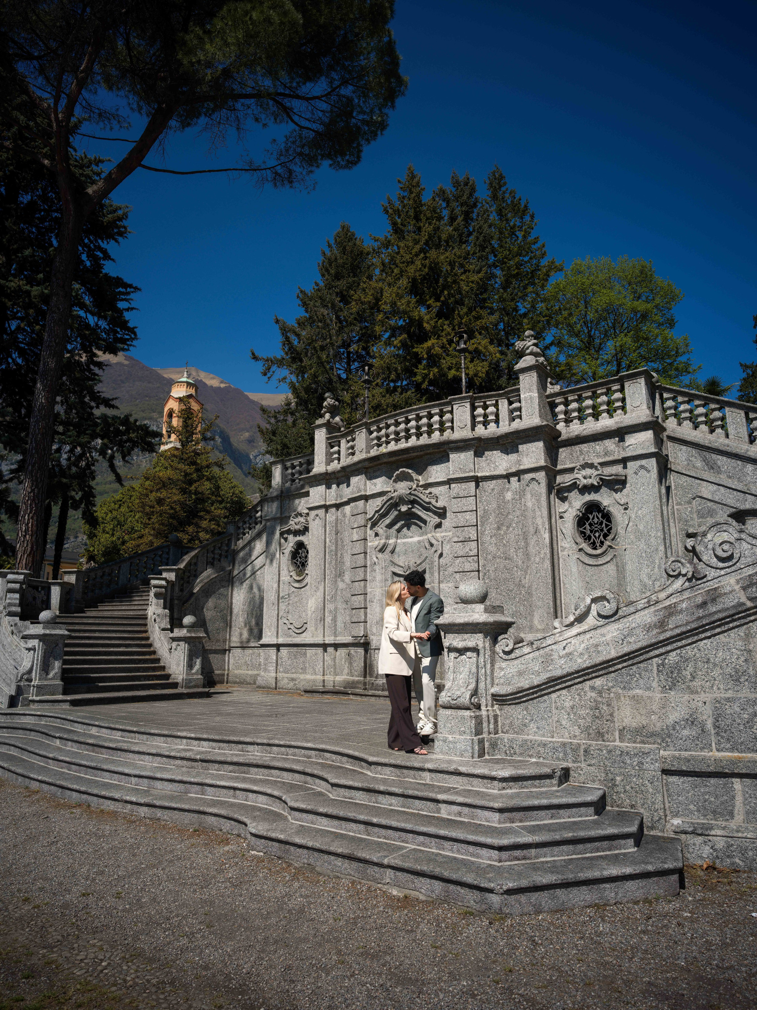 Proposal, Parco Civico Teresio Olivelli, Tremezzo, Lake Como – newly engaged couple embracing on the park stairs