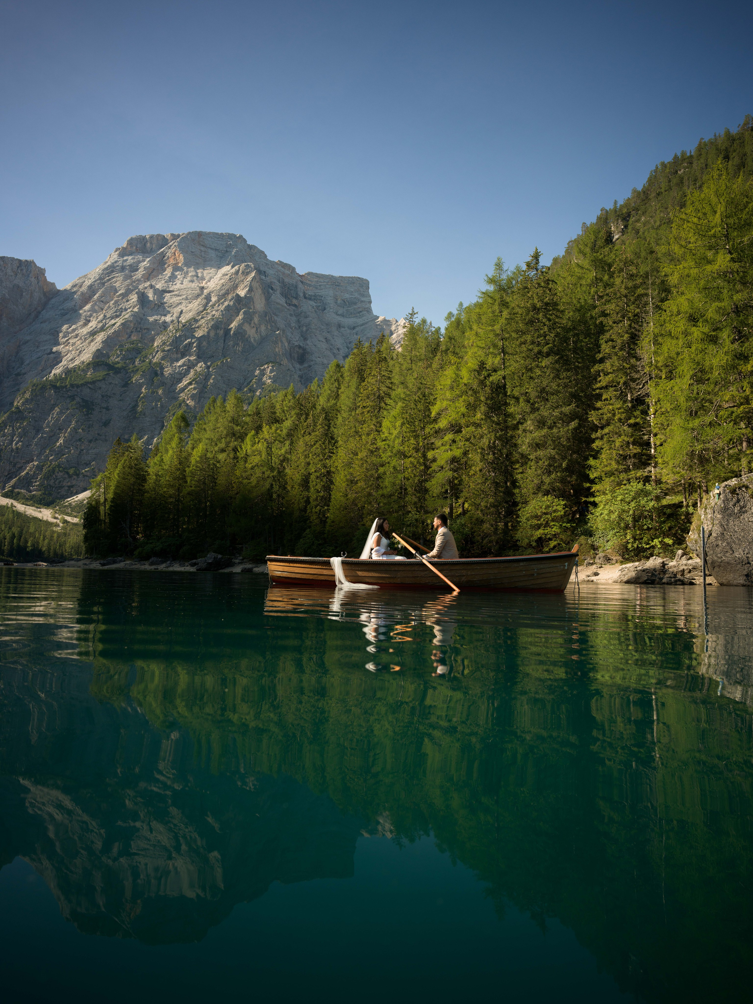 Dolomites Lake Braies elopement couple photography on a wooden boat and cinematic photoshoot around the alpine lake