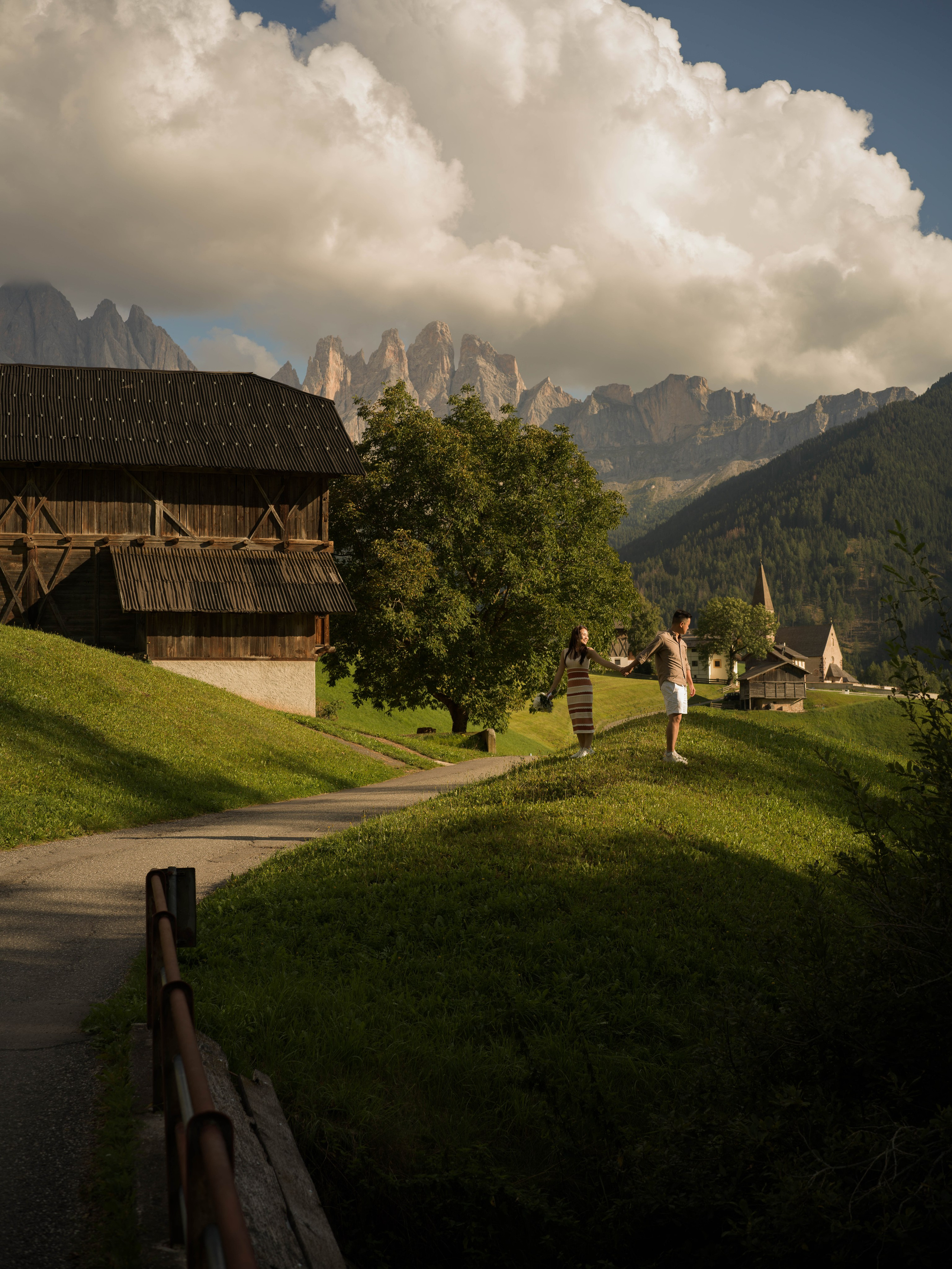 Couple during a sunset proposal in Santa Maddalena, with the Dolomites mountains and alpine landscape in the background