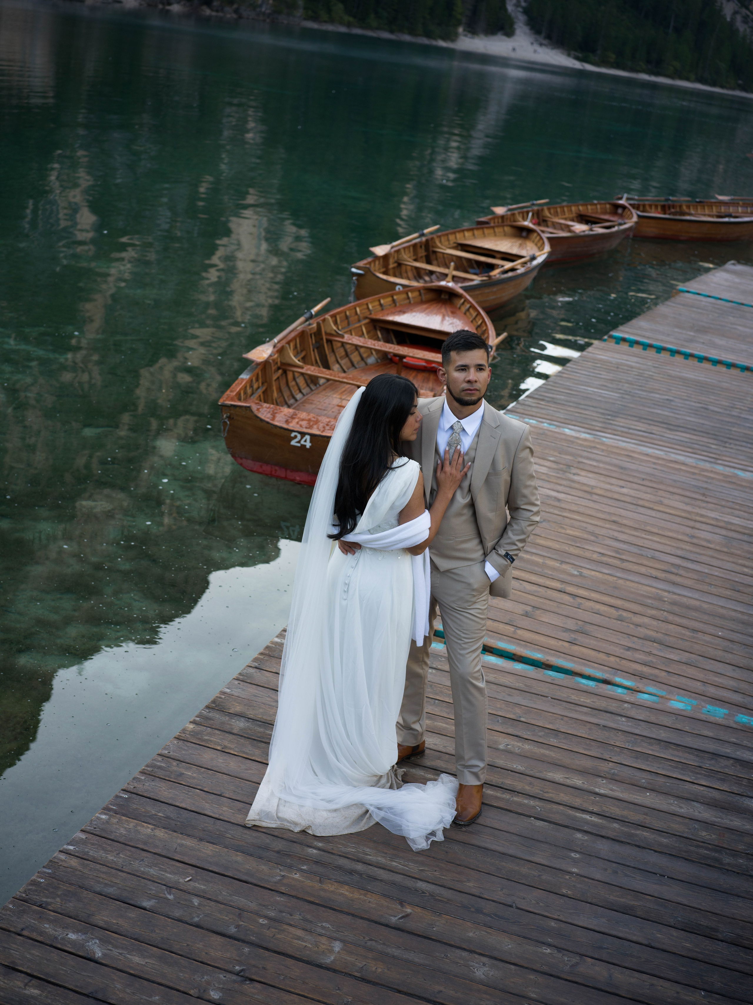 Lake Braies elopement at sunrise, couple near the iconic boathouse on Lago di Braies in the Dolomites, Italy