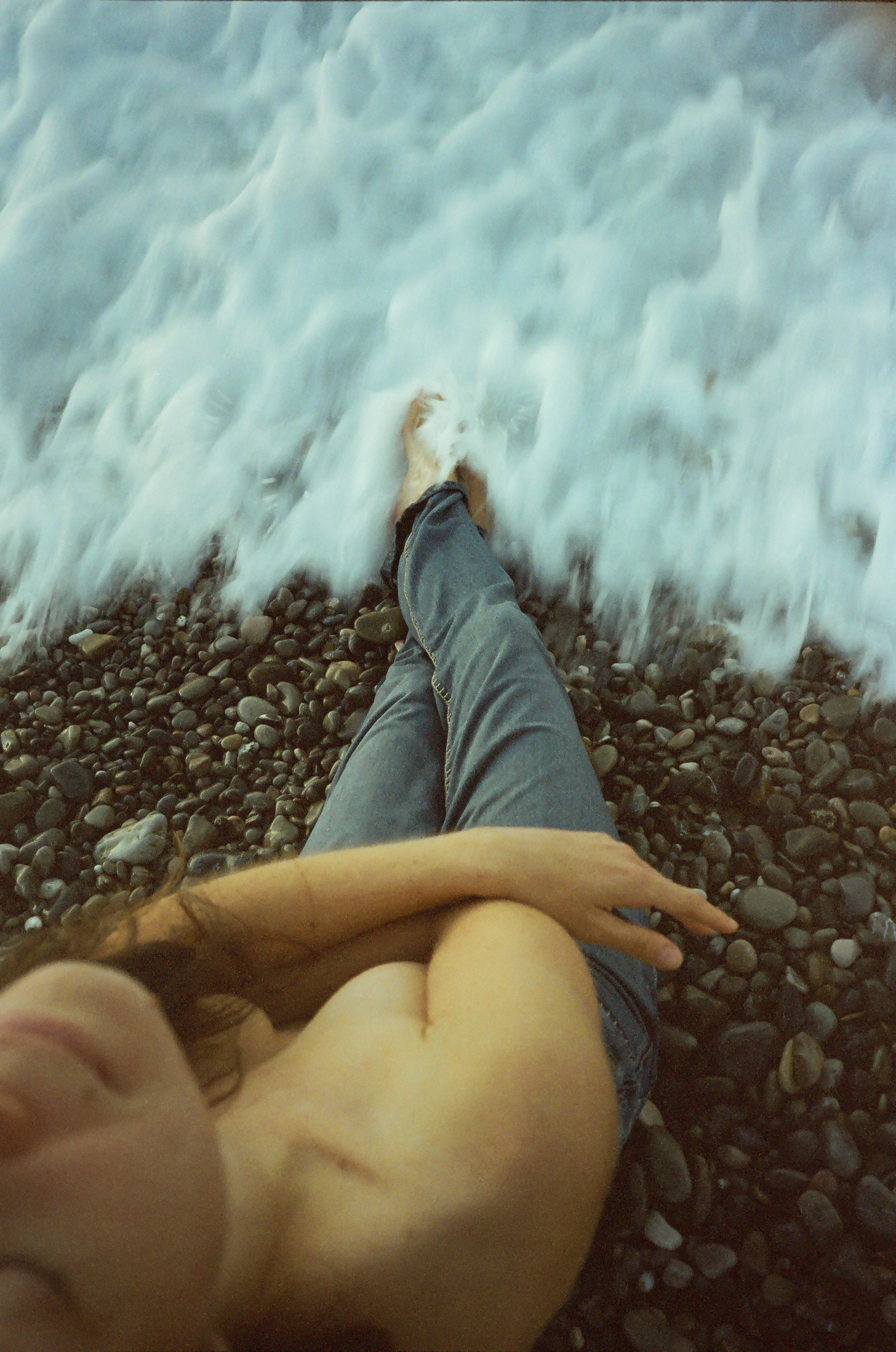 Fine art film photography, Nice, France – sea waves covering a woman's feet and legs, dreamy dawn on the French Riviera