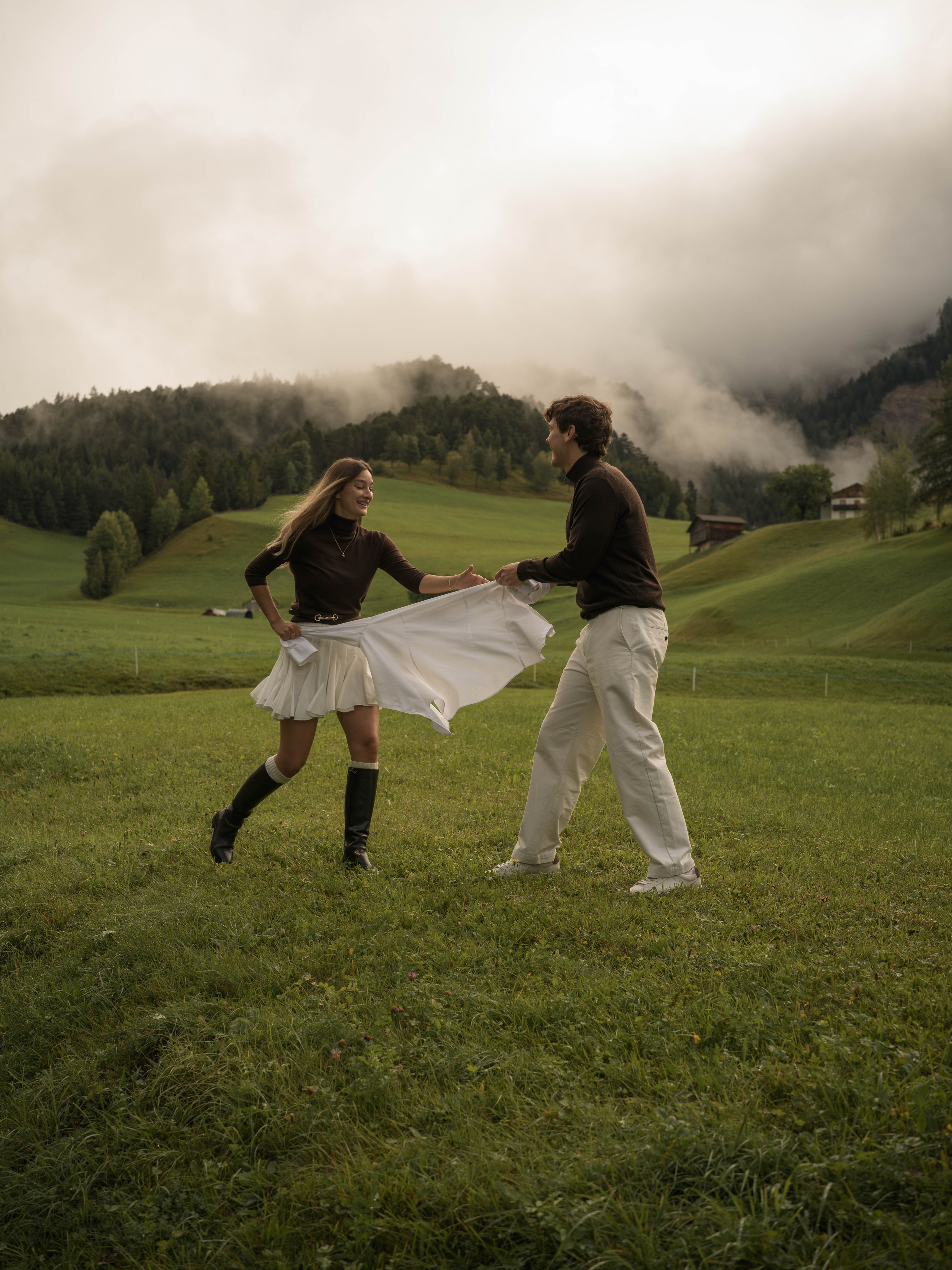 Luxury surprise proposal and engagement photoshoot in Santa Maddalena, Val di Funes, featuring a couple surrounded by the dramatic peaks of the Italian Dolomites.