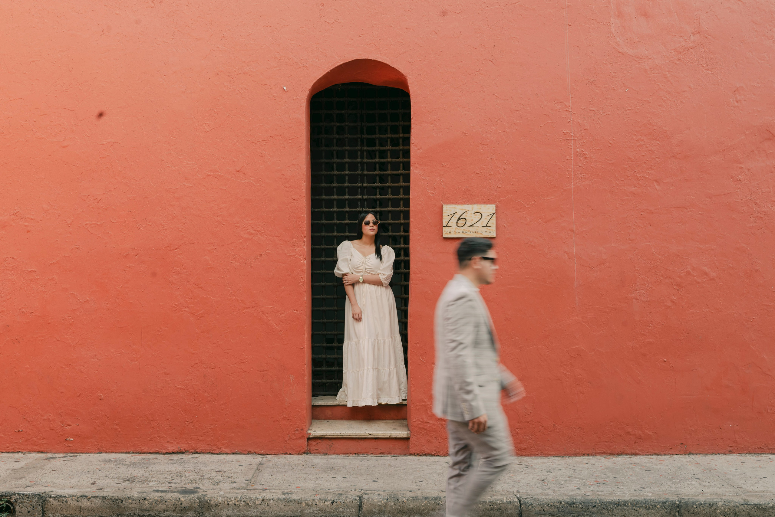 Pareja posando frente a puerta roja, locación emblemática de Cartagena cinematográfica