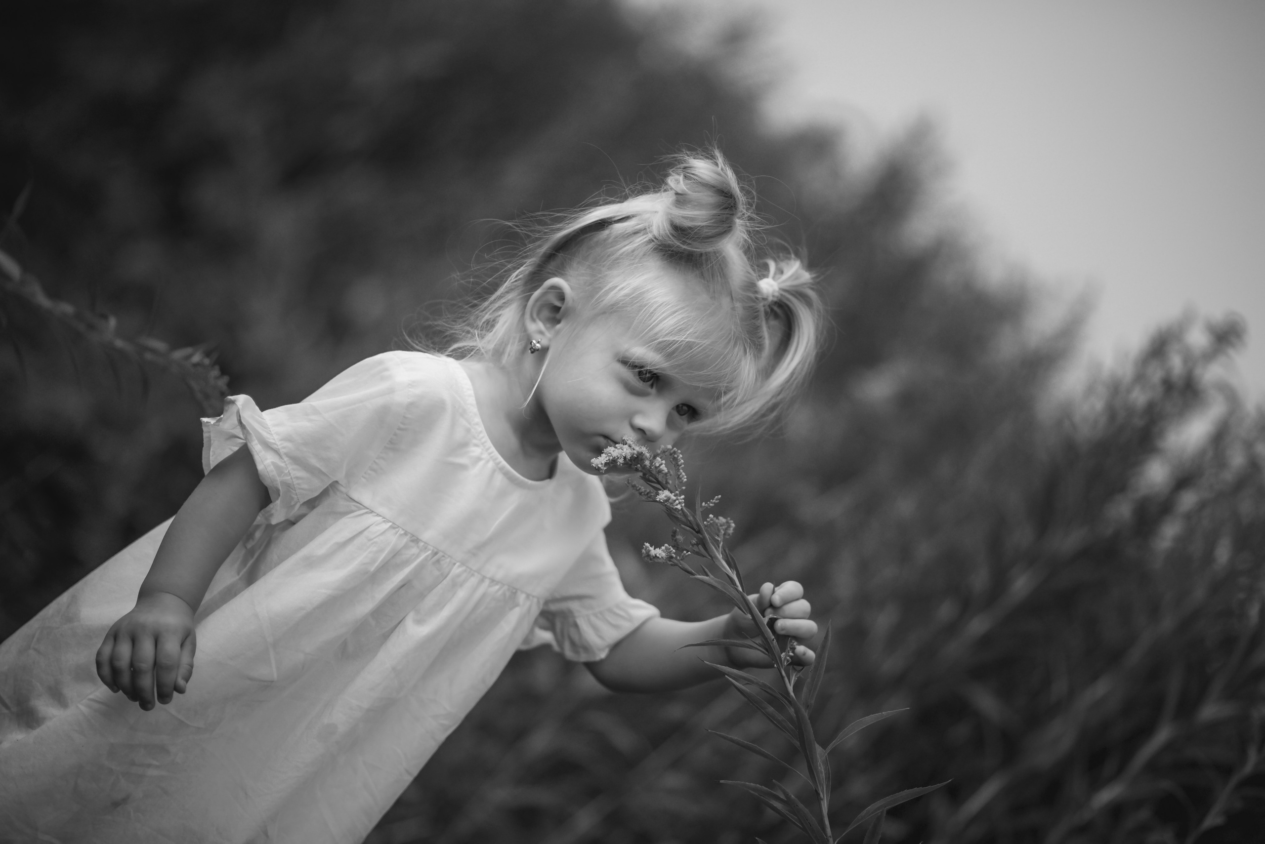 Little girl standing in tall grass and smiling