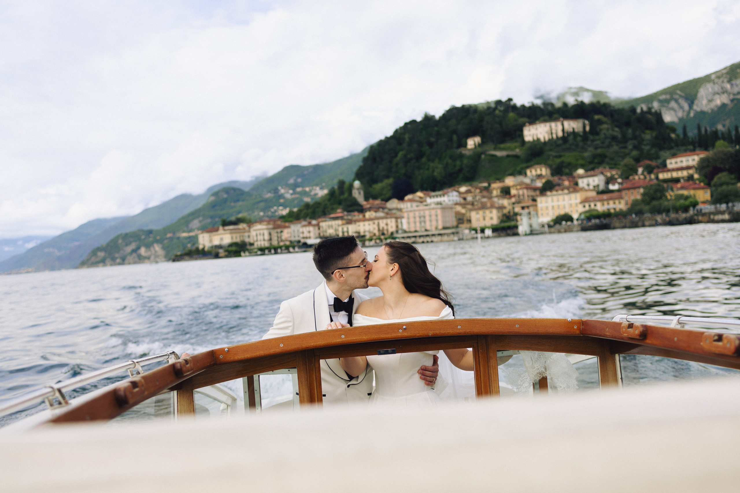 Bride and groom kissing on a boat during their intimate Lake Como wedding in Bellagio, Italy