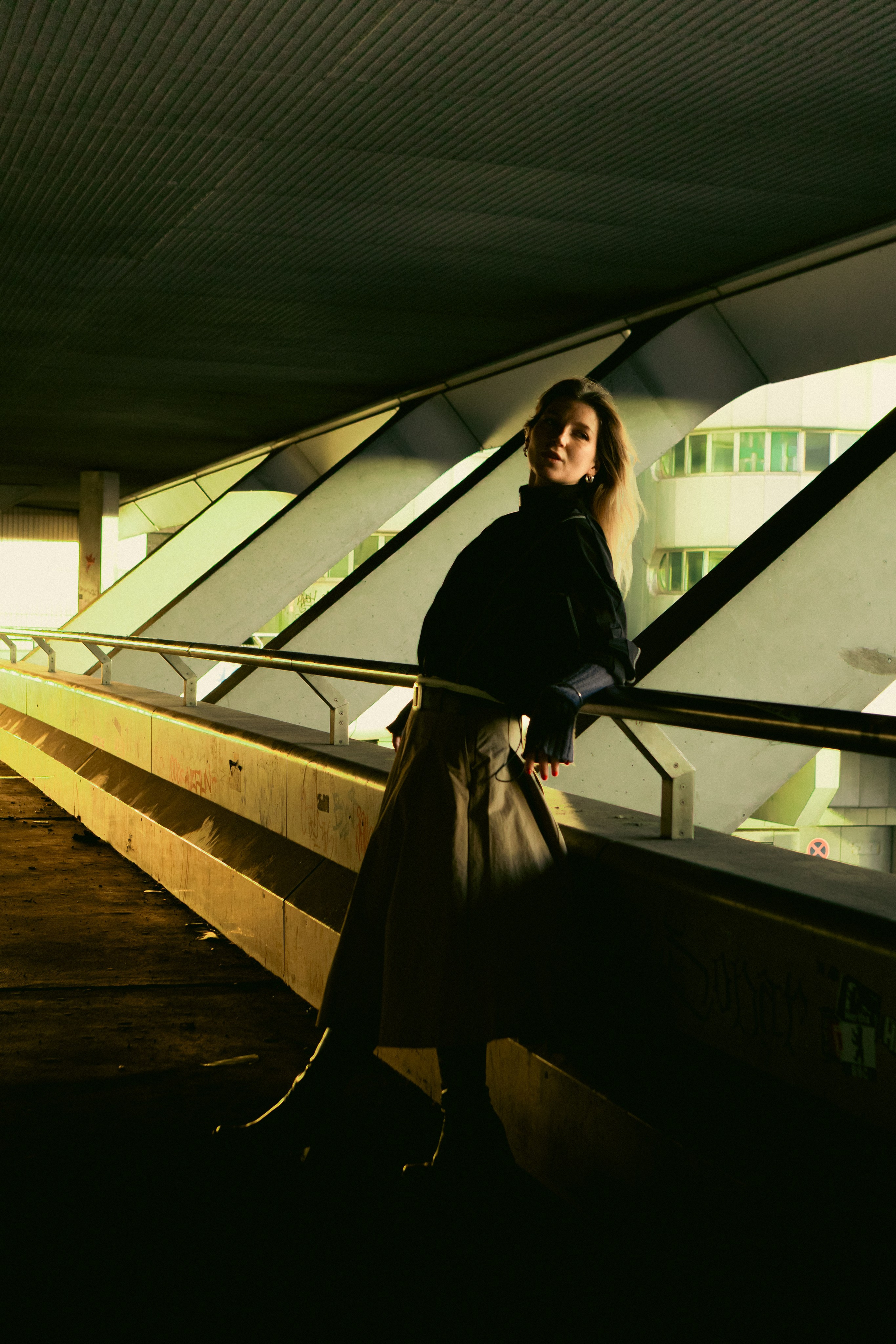 Cinematic female portrait in a Berlin underpass with graffiti-covered walls and dramatic light