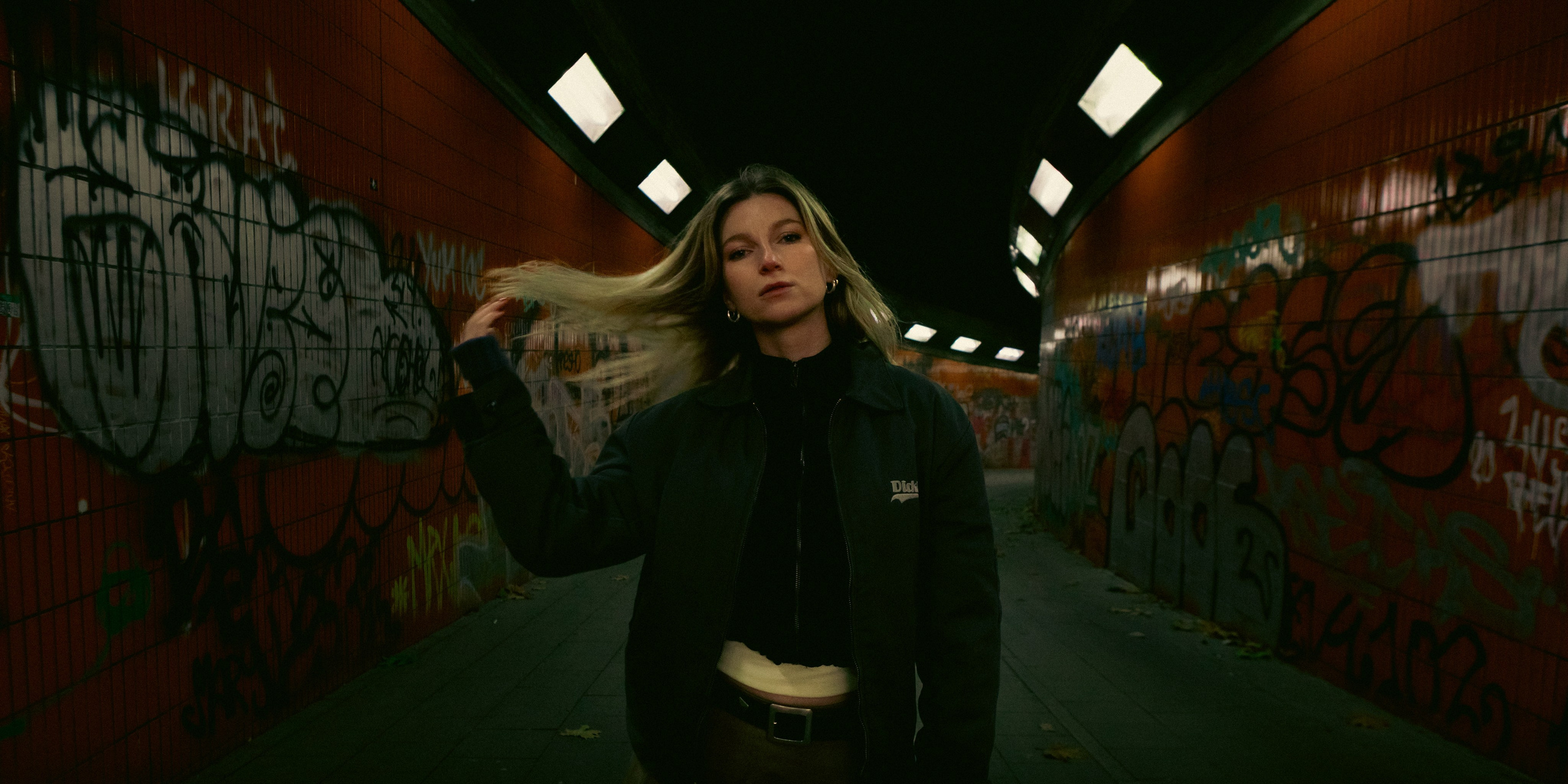 Female portrait in a Berlin architectural underpass with graffiti and geometric lines