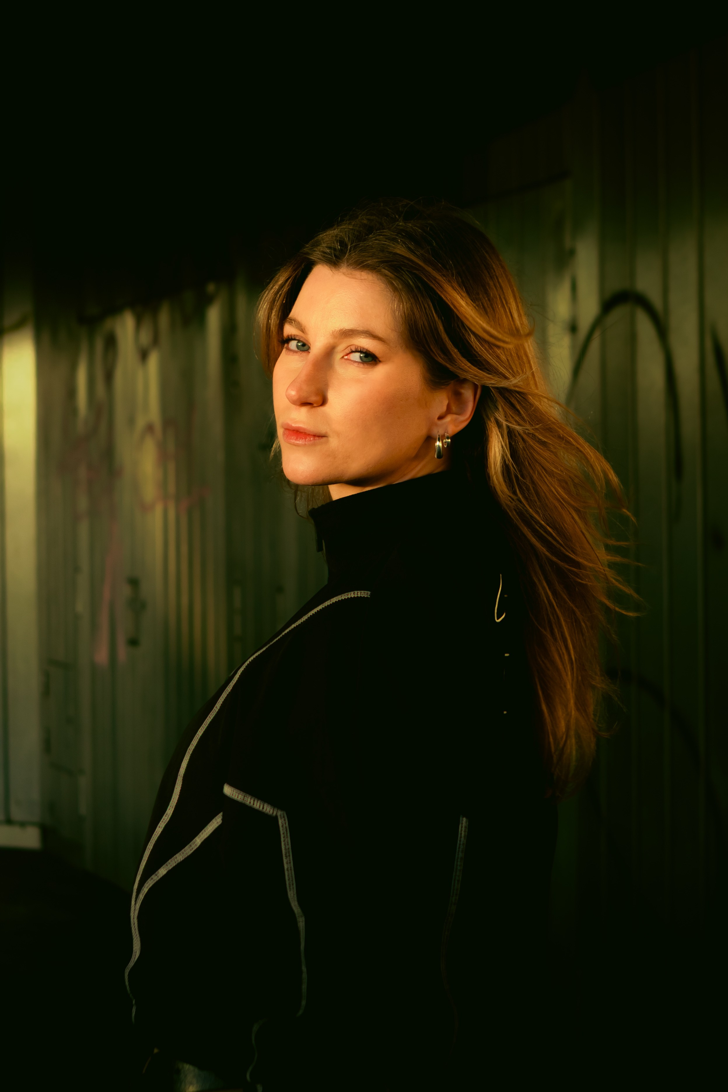 Cinematic portrait of a woman in a Berlin underpass with graffiti, geometric lines and moody lighting