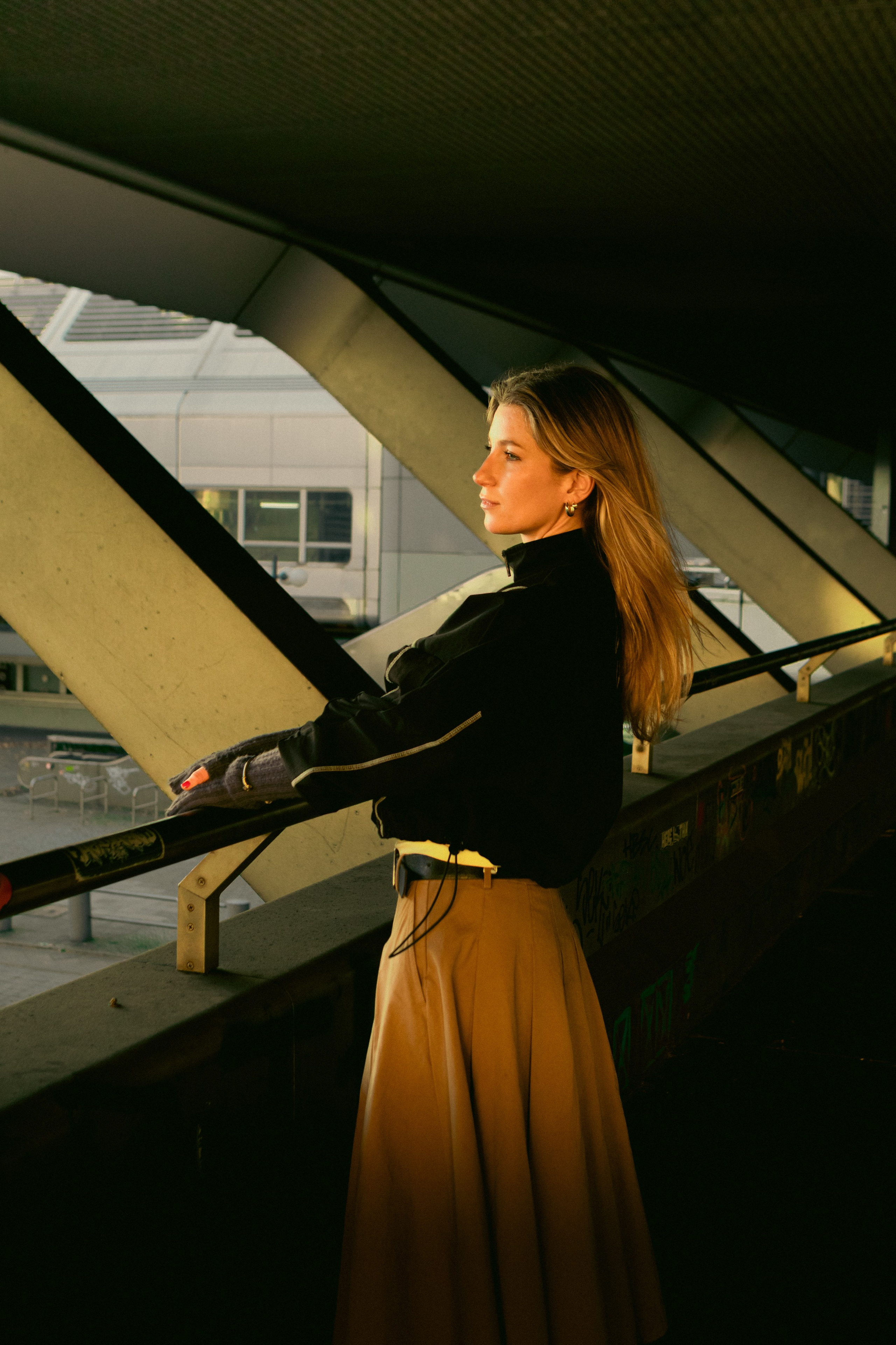 Moody female portrait in a Berlin urban underpass with graffiti, tiled walls and cinematic light