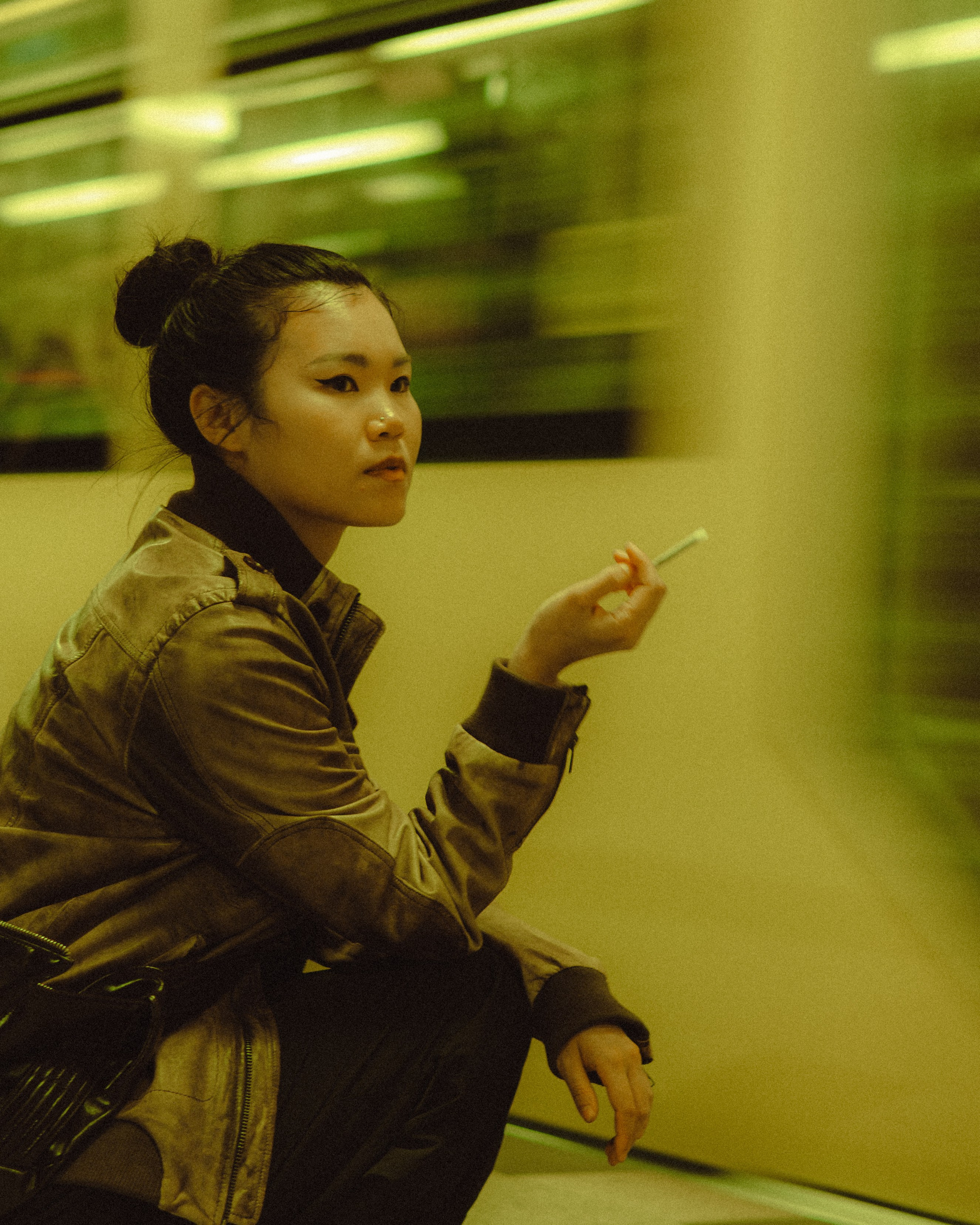 Woman sitting on a Berlin U-Bahn platform with a blurred train behind her