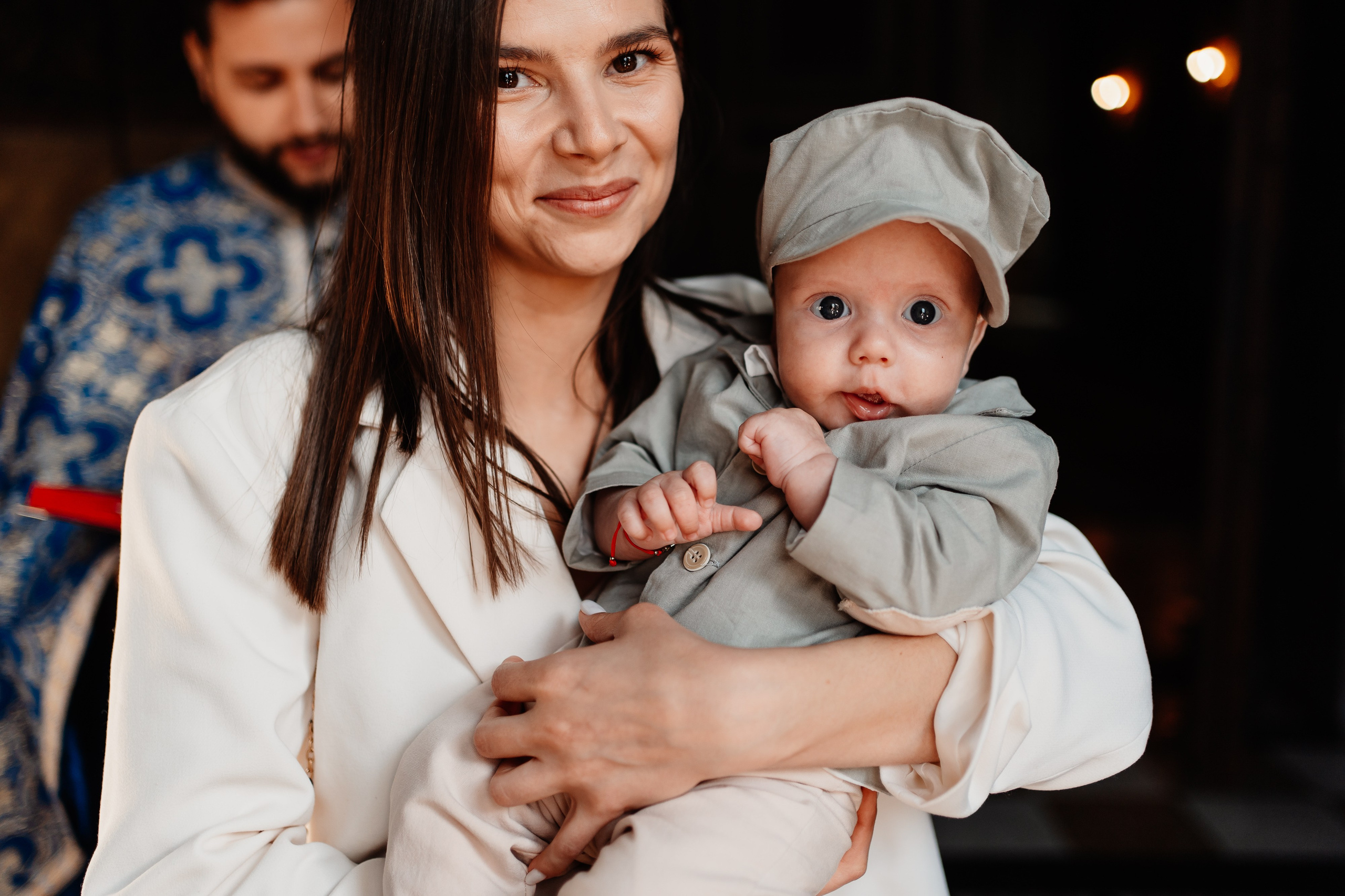 Instantaneu plin de tandrețe dintre părinți și bebeluș în ziua botezului, realizat în Craiova. Fotografie profesională de botez, capturând emoțiile autentice ale familiei într-un decor luminos și cald