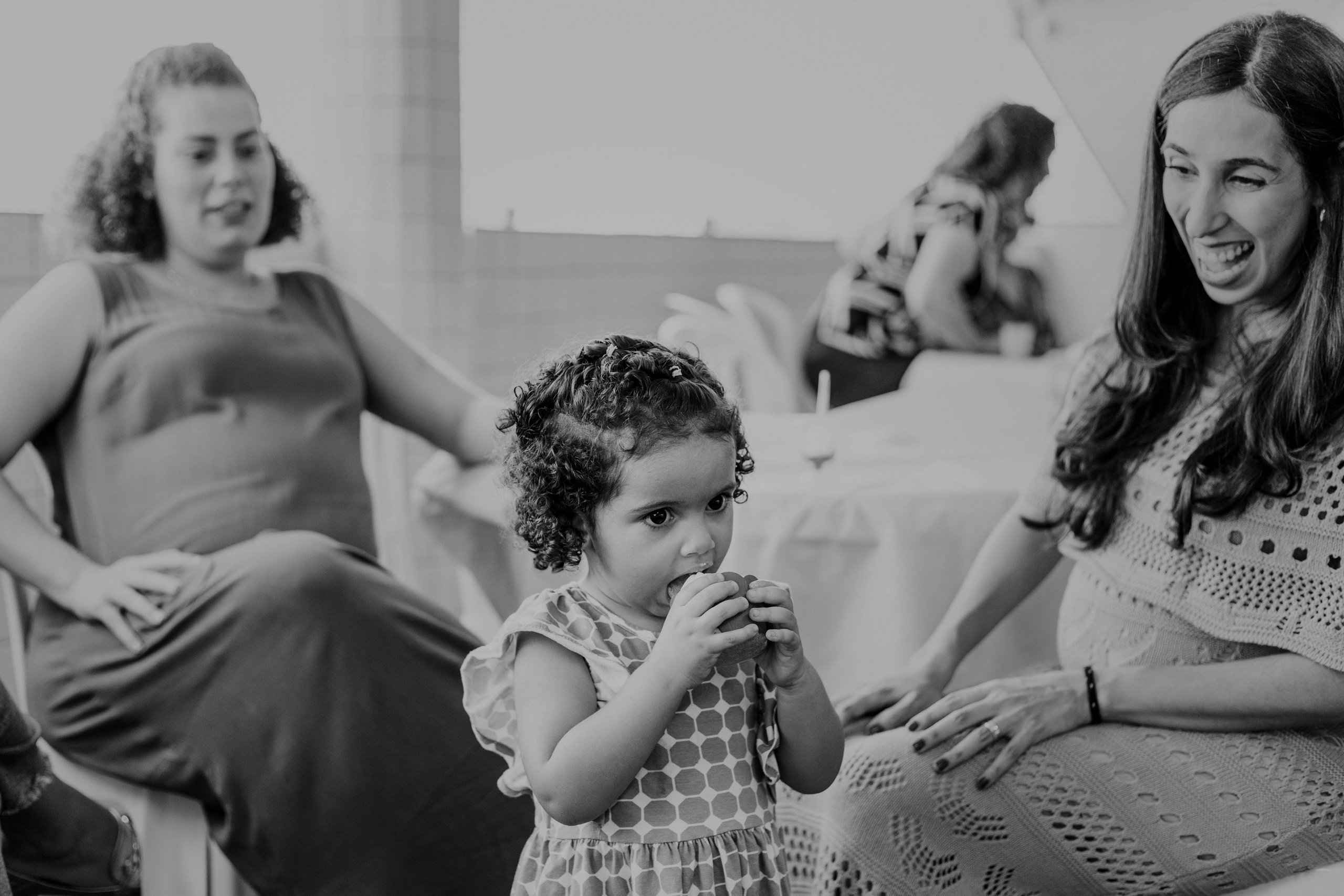 Criança com cupcake enquanto adultos reagem em festa infantil