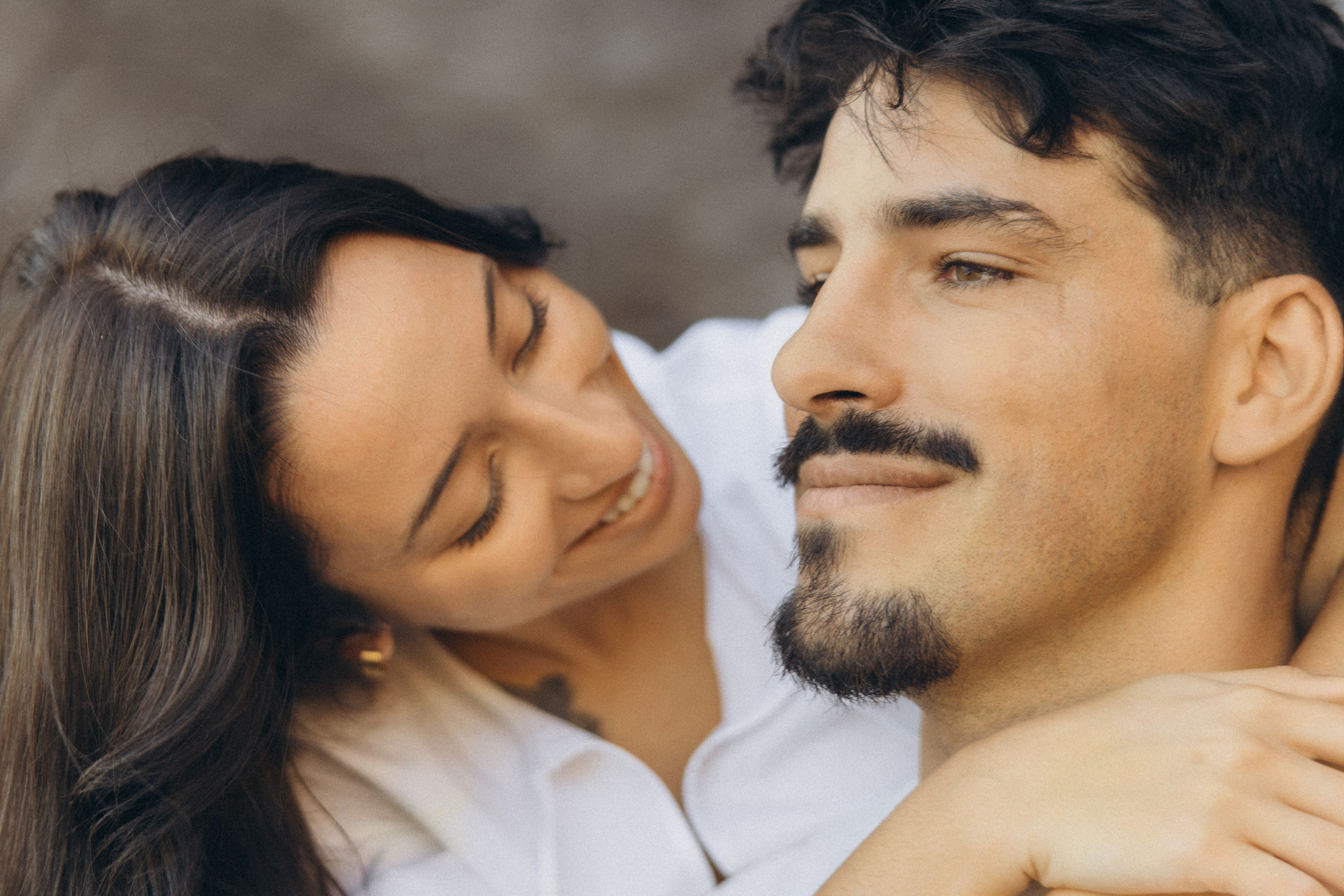 Couple sharing a romantic moment during sunset on Madeira Island, with the ocean and cliffs in the background