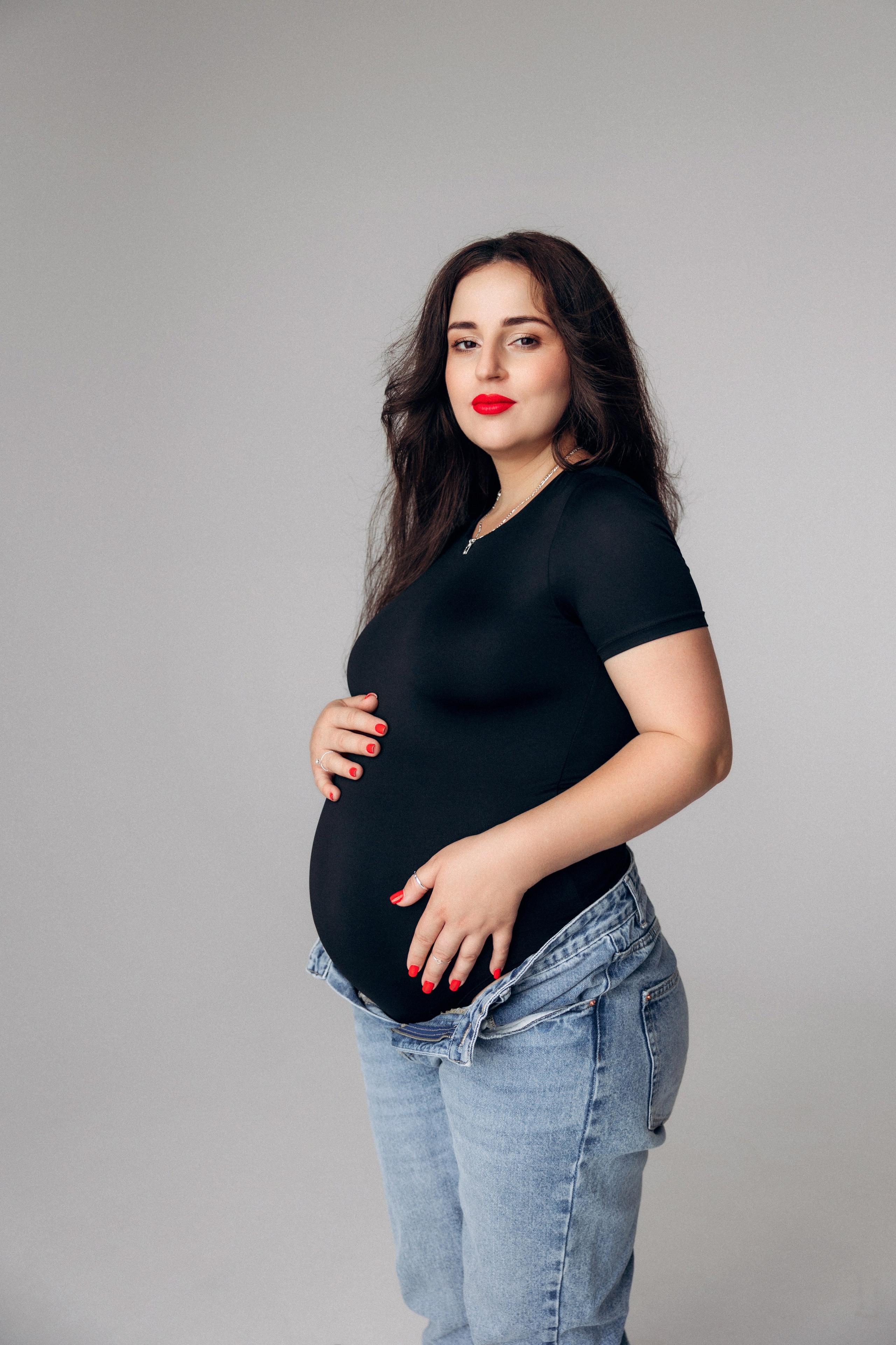 Portret przyszłej mamy – spokojna poza i skupienie na tym, co najważniejsze.