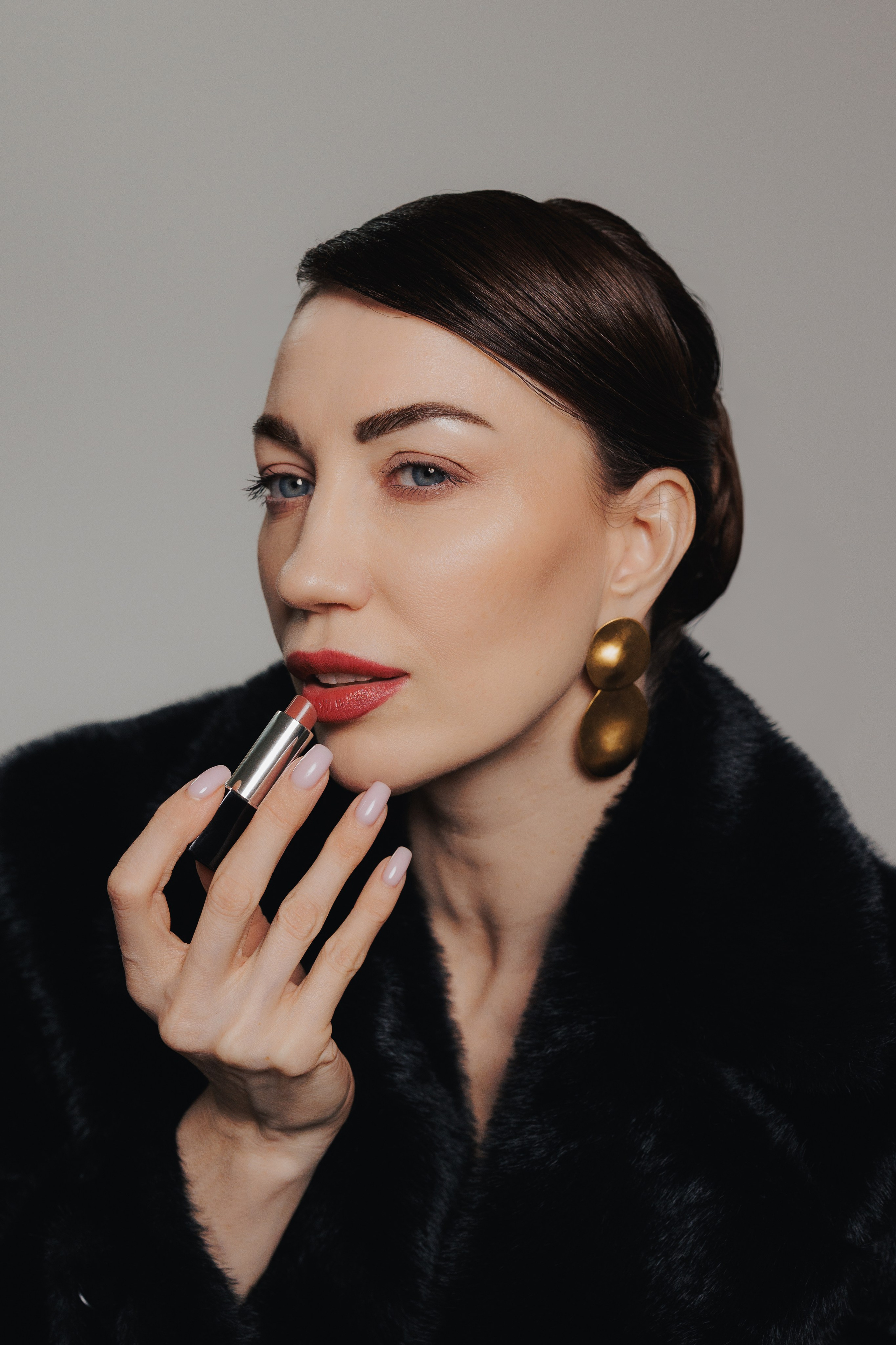 Elegant close-up portrait of a woman wearing a black fur coat and statement earrings in soft dramatic studio lighting, photographed in Leipzig, Germany. Элегантный крупный портрет девушки в чёрной шубе с выразительными серьгами в мягком драматичном студийном свете, снятый в Лейпциге, Германия.
