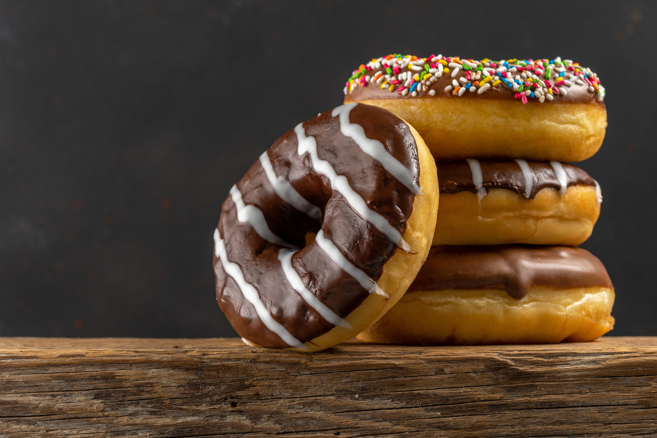 Delicious donuts on rustic wooden table.