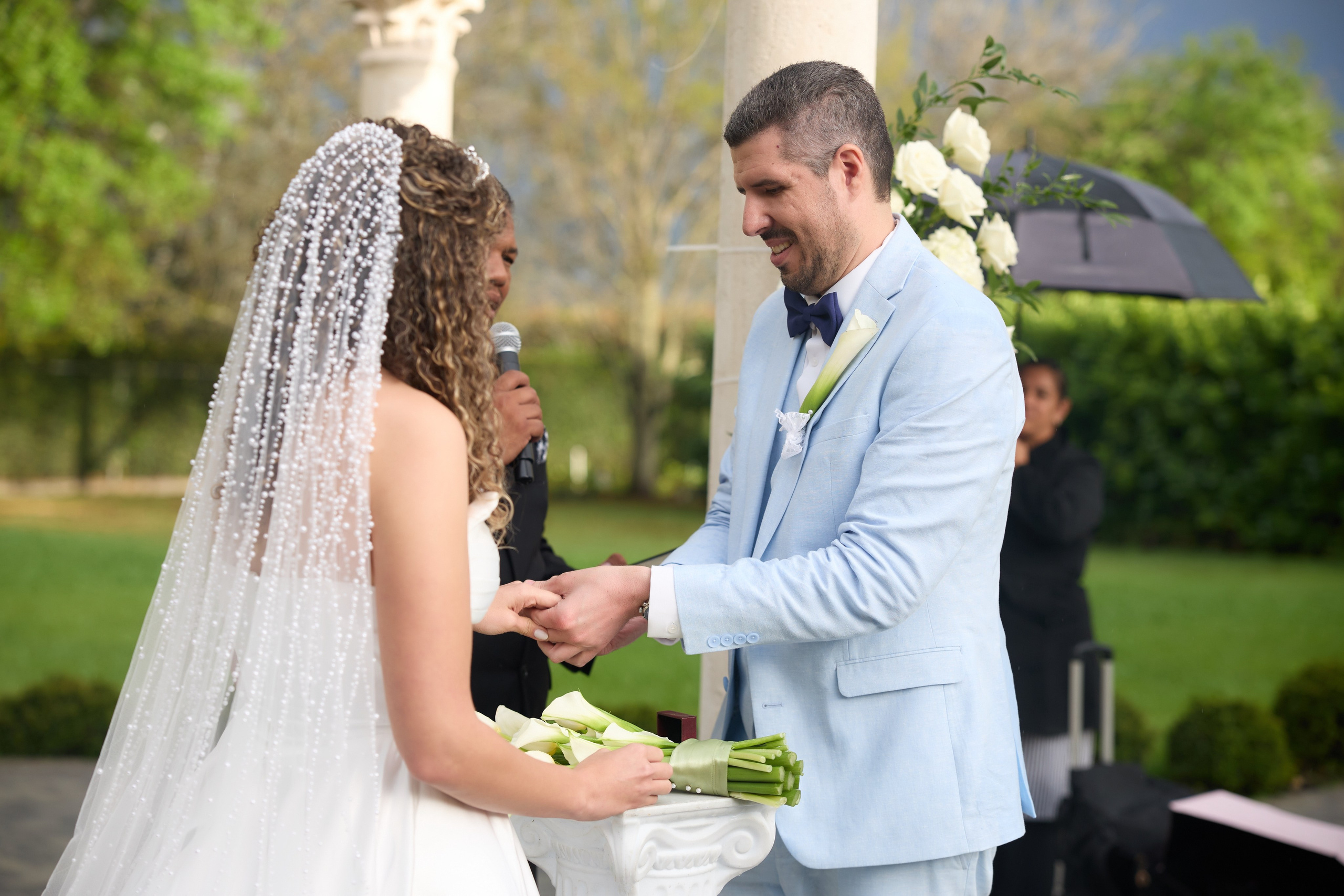 Bride and groom exchanging rings during a garden wedding ceremony