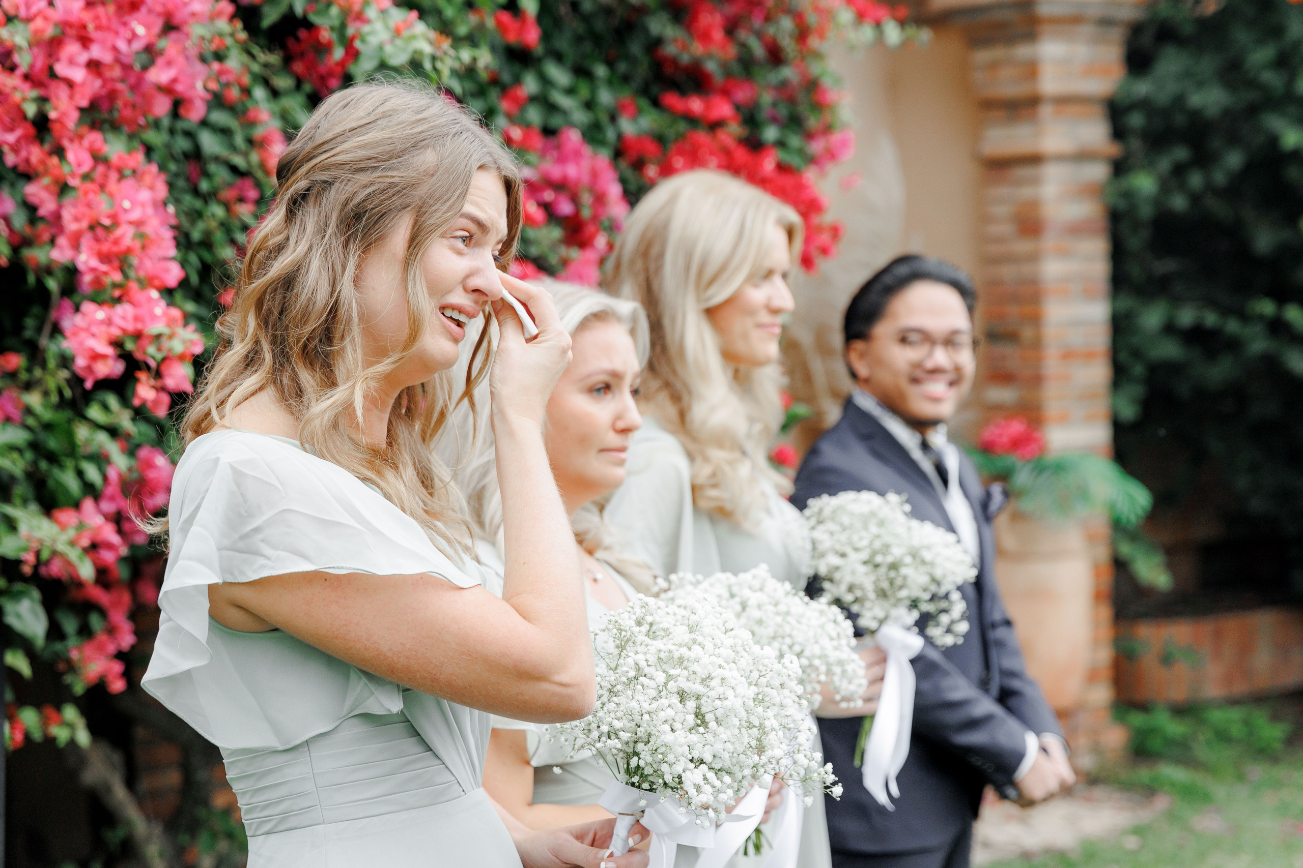 Bridesmaids in matching dresses share the bride's emotions during the wedding ceremony in Barcelona. 