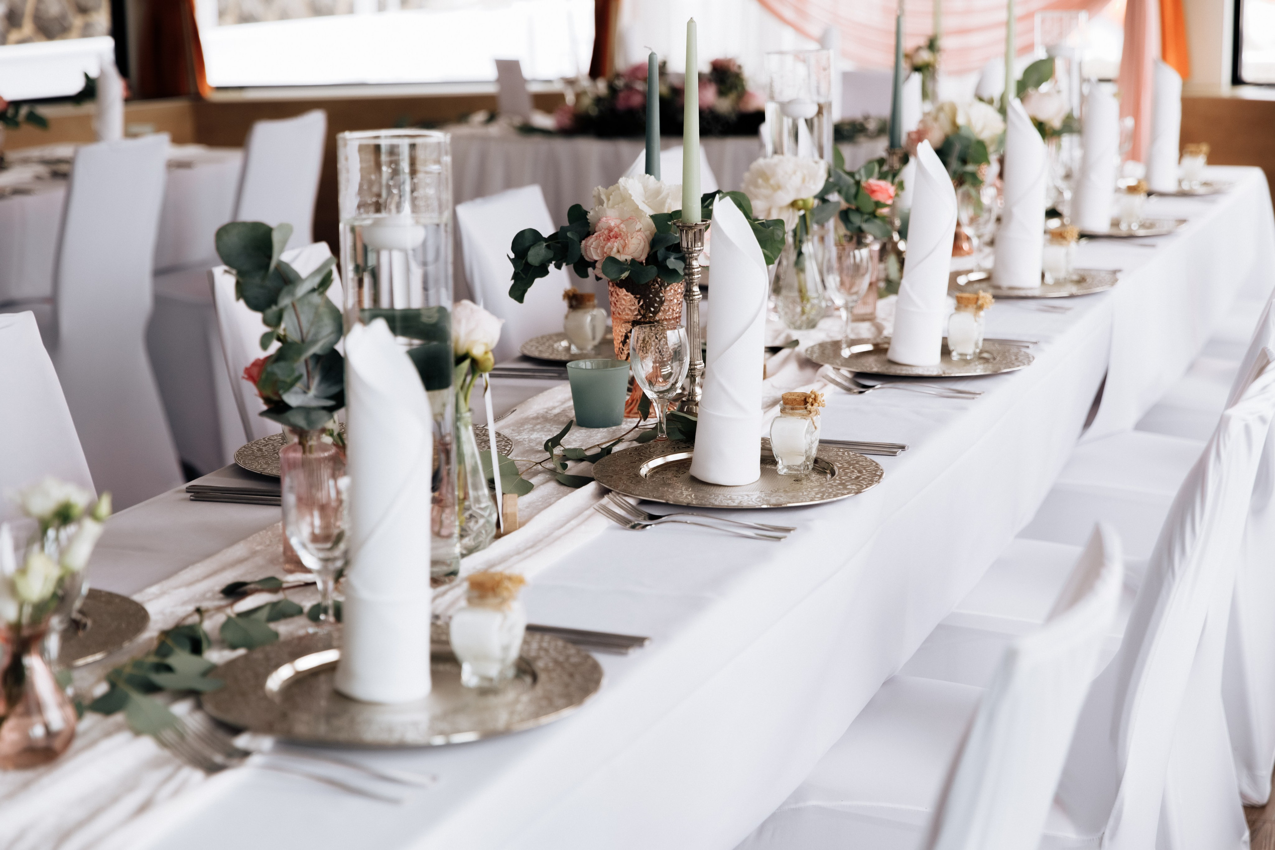 Hochzeitstisch dekoriert in zarten Pfirsich- und Weißtönen. 