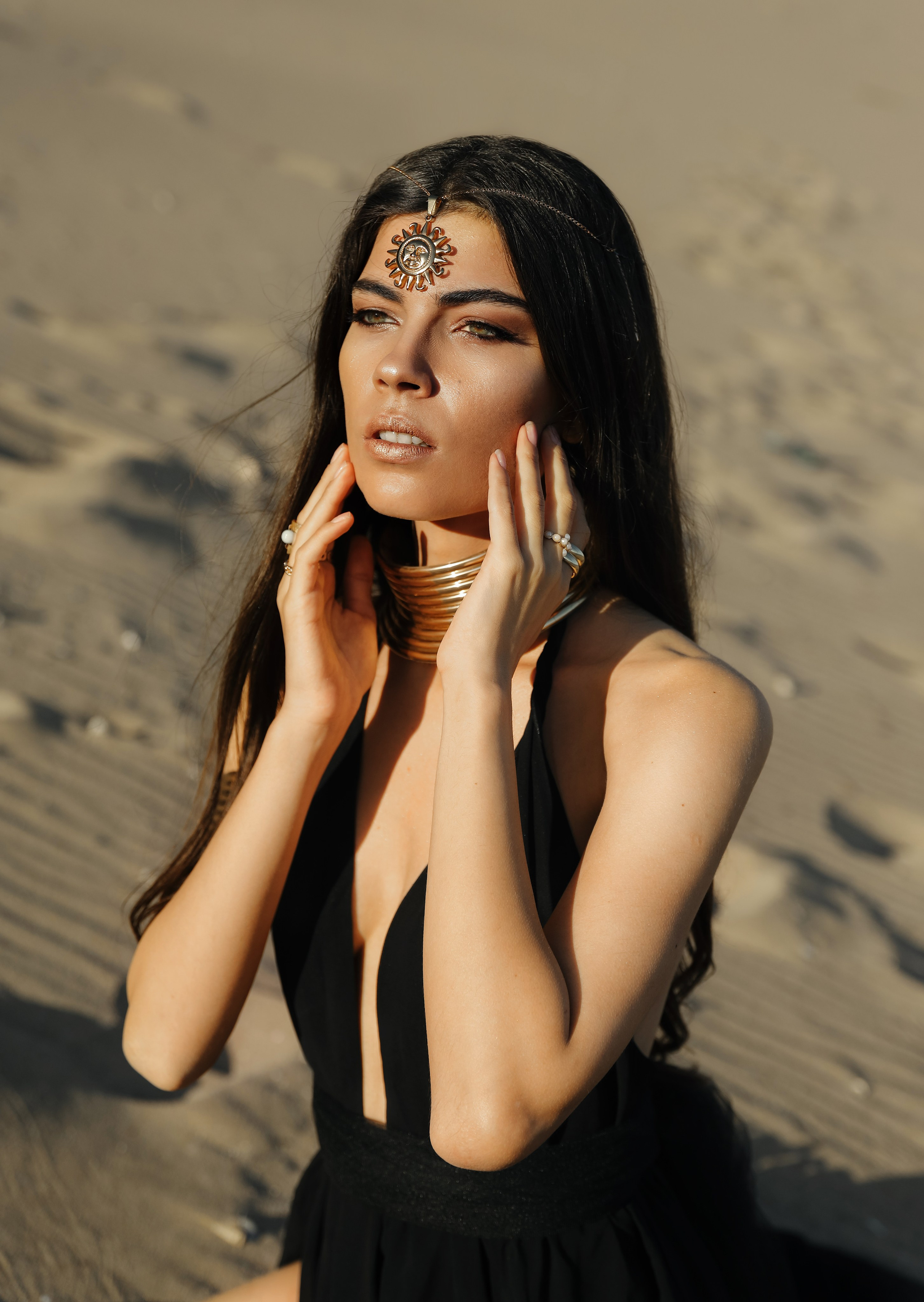 A chic girl in a black dress and golden accessories in the Desert. Rhodes island, Greece