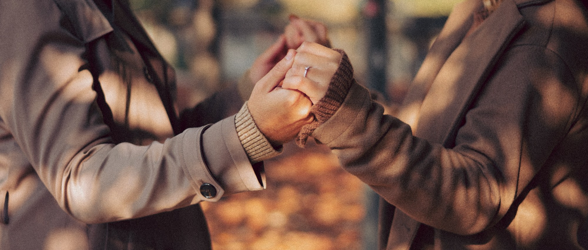Engagement Ring Close-Up — Romantic Fall Couple Photography. A warm and intimate close-up of a couple holding hands during a fall photoshoot. The engagement ring sparkles in the soft autumn light, capturing a tender and emotional moment. Perfect inspiration for engagement photography, fall couple sessions, proposal shoots, and romantic detail shots. engagement ring photo, couple hands close up, fall engagement session, romantic detail shot, autumn couple photography, engagement photography ideas, cozy fall photoshoot, couple holding hands, natural light photography, warm tones aesthetic