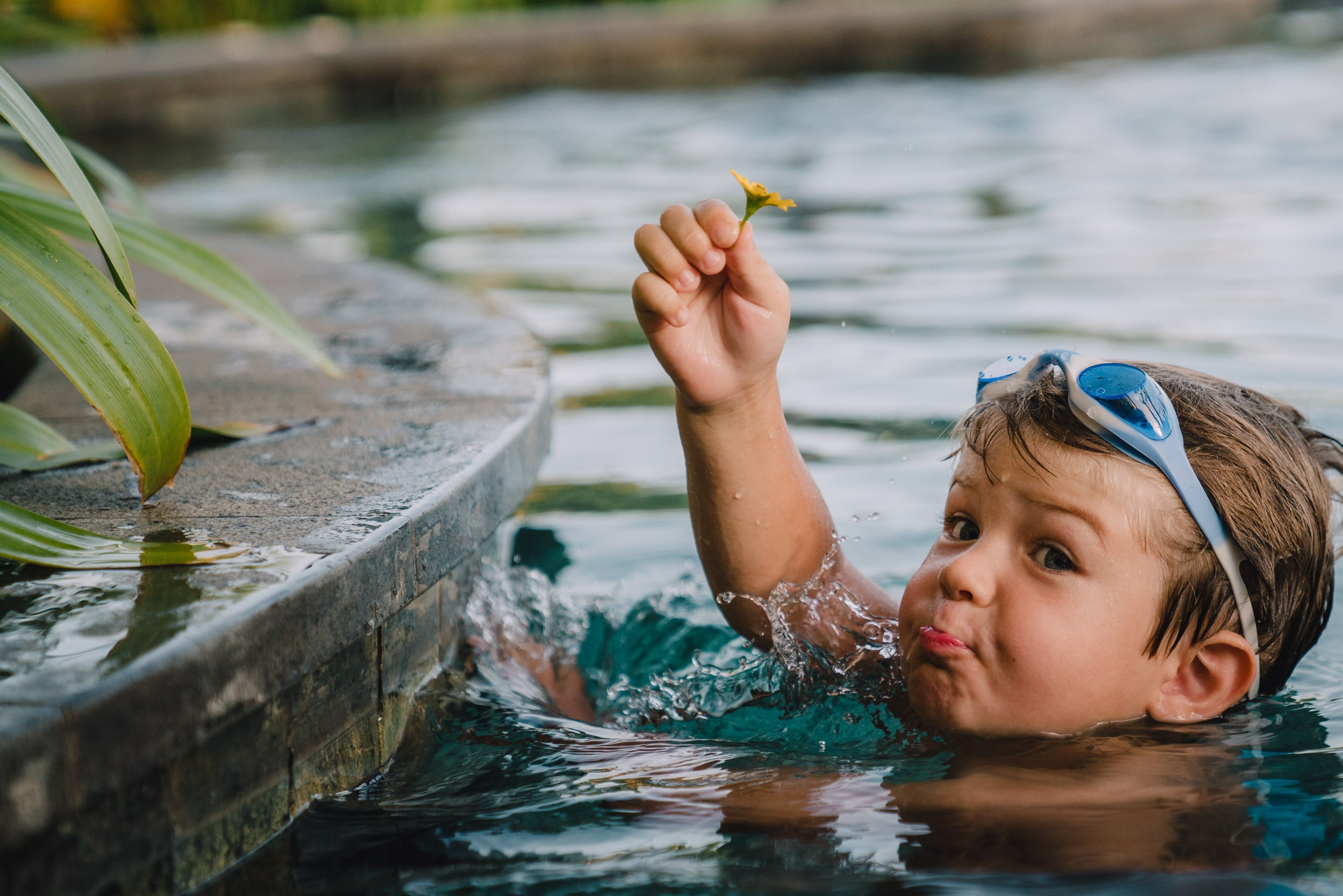 Young swimmer holding the flower enjoying himslef