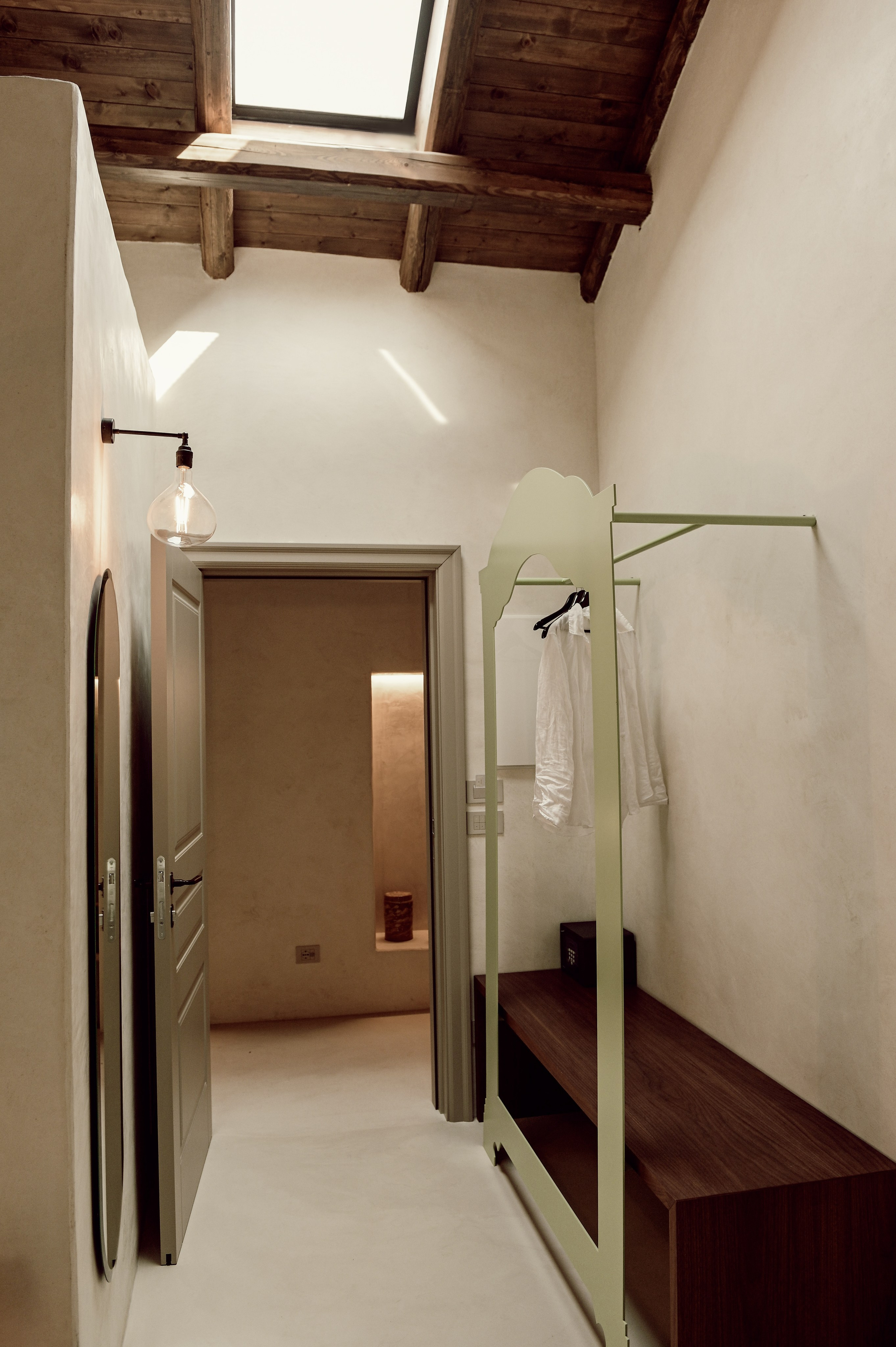 Natural light hallway interior with rustic wooden ceiling, skylight, and minimal custom wardrobe, modern Puglia design