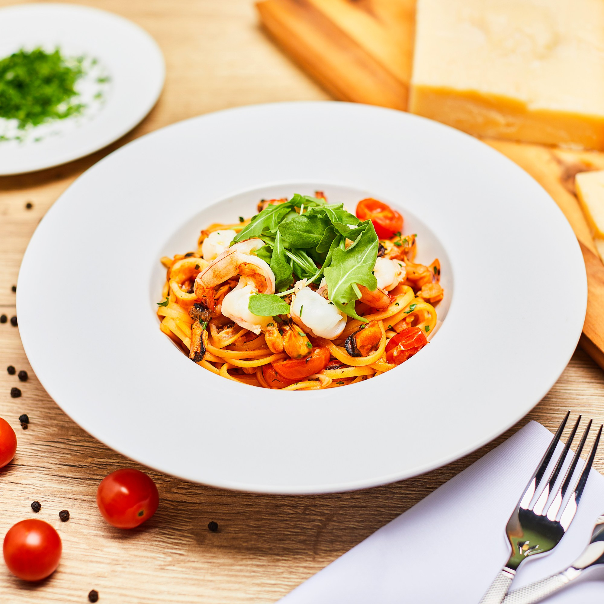Photographer Roman Djuzev - Spaghetti marinara with seafood in a white plate on a wooden table.