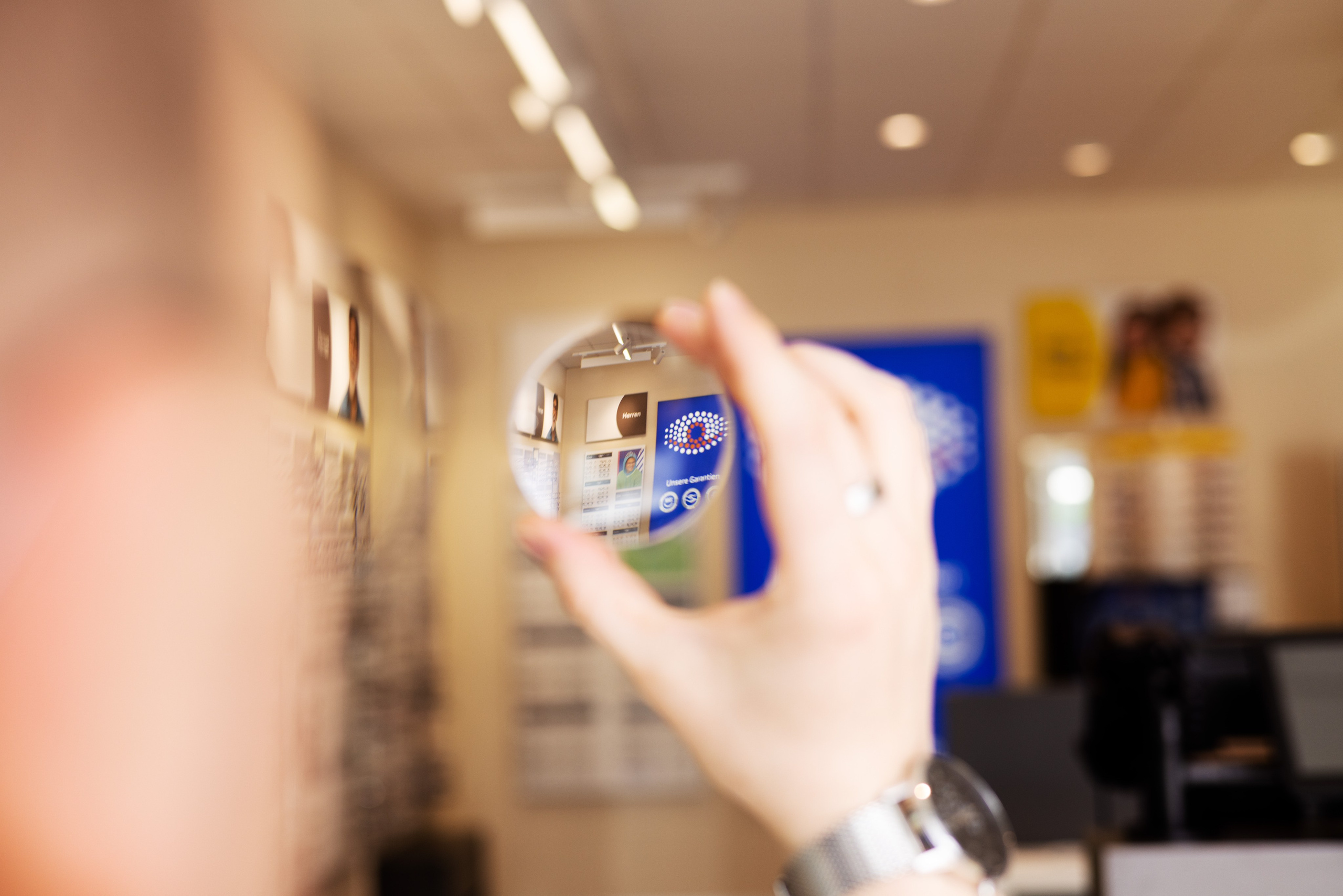 Image-Foto für Optiker – Brillenreparatur: „Nahaufnahme eines Optikers bei der Reparatur einer Brille, sorgfältige Handarbeit und Präzision