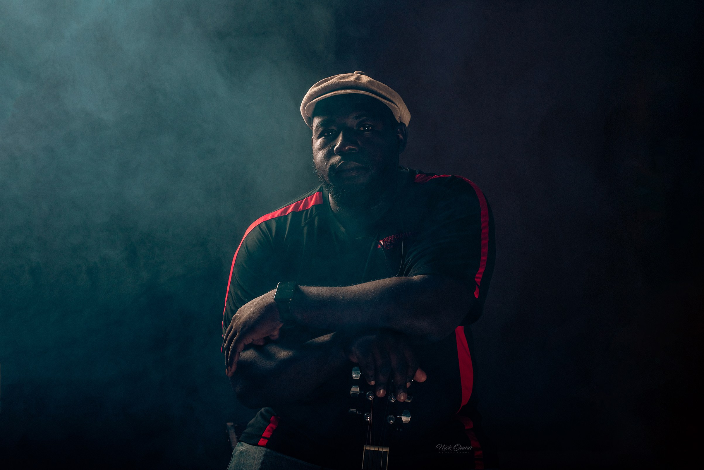 Cinematic moody portrait of a musician holding a guitar by Nick Ouma photography