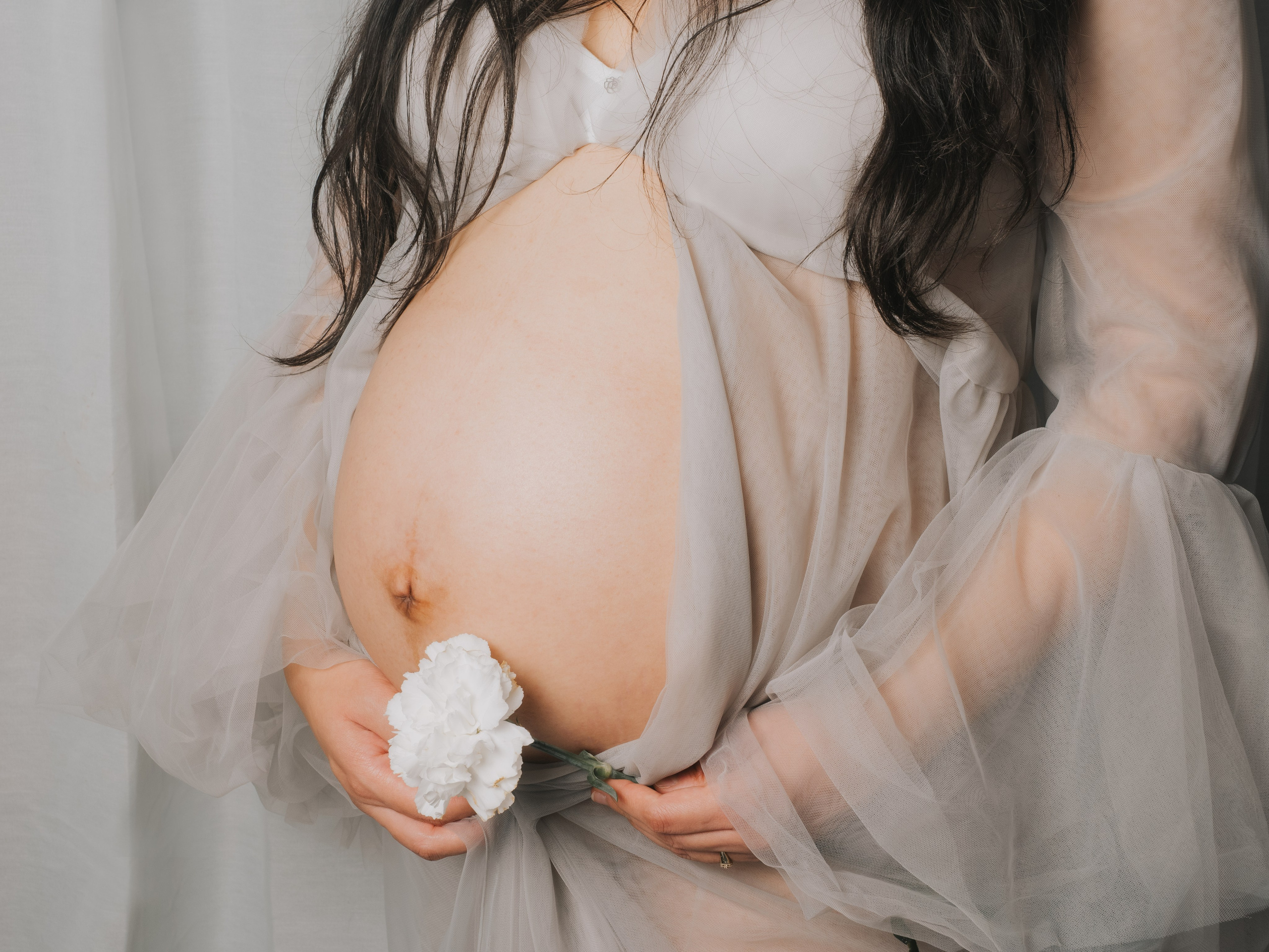 Pregnant belly with a white flower.