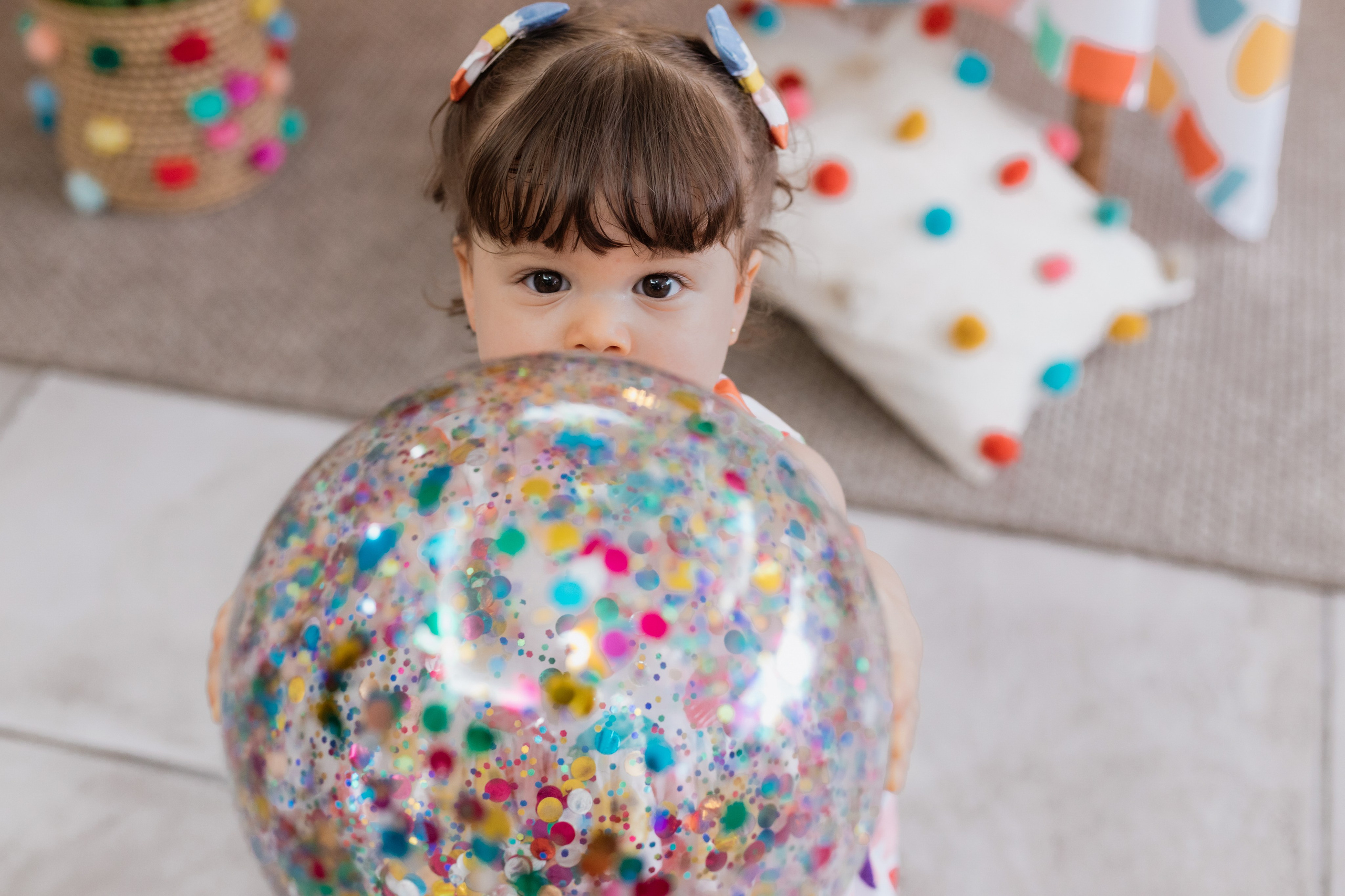 Menina com bola colorida em festa de 1 ano