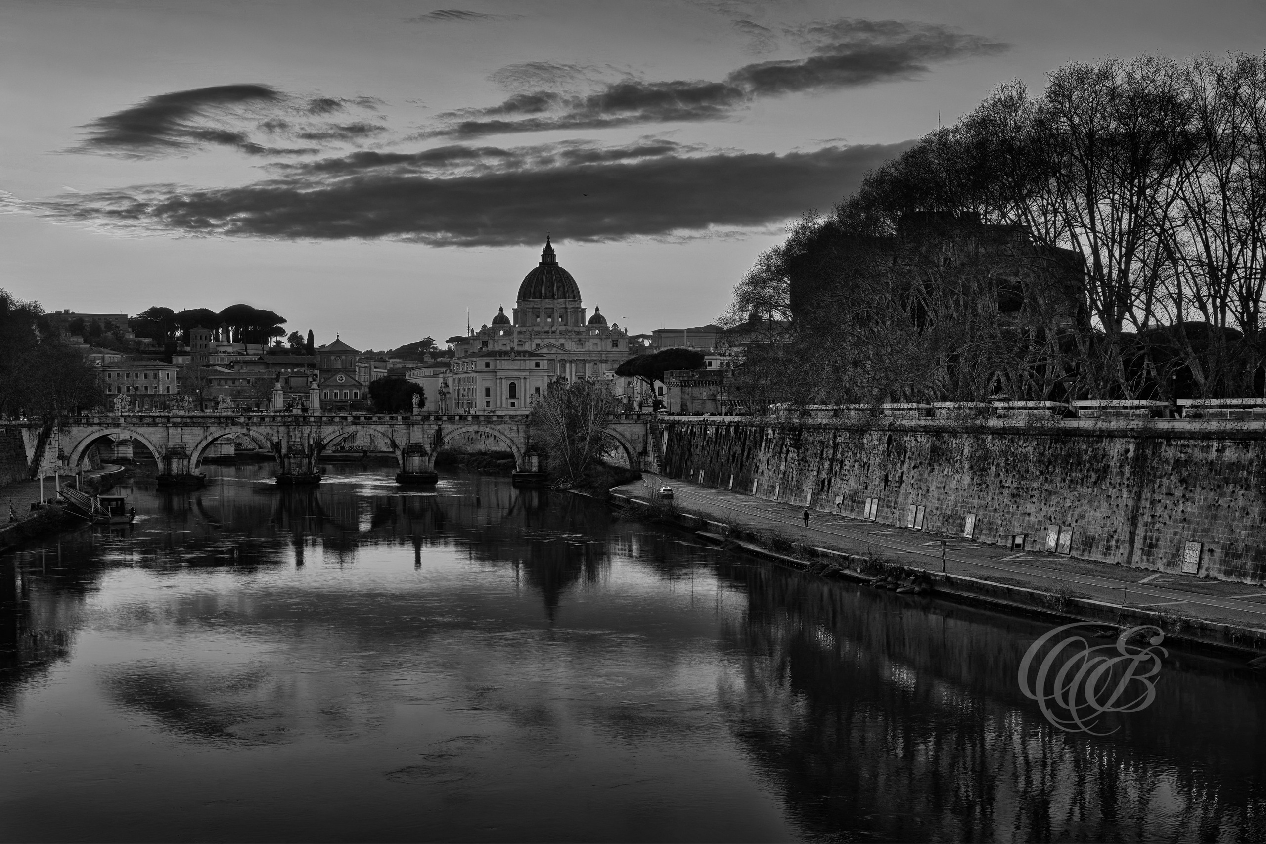 Rome Italy - The Ponte Sant'Angelo & St. Peter's Basilica - B&W - Eduardo Bartoli Fine Art Photography - Black and white fine art photograph showing the silhouette of Ponte Sant’Angelo and the dome of St. Peter’s Basilica from afar in Rome, Italy – photography by Eduardo Bartoli.