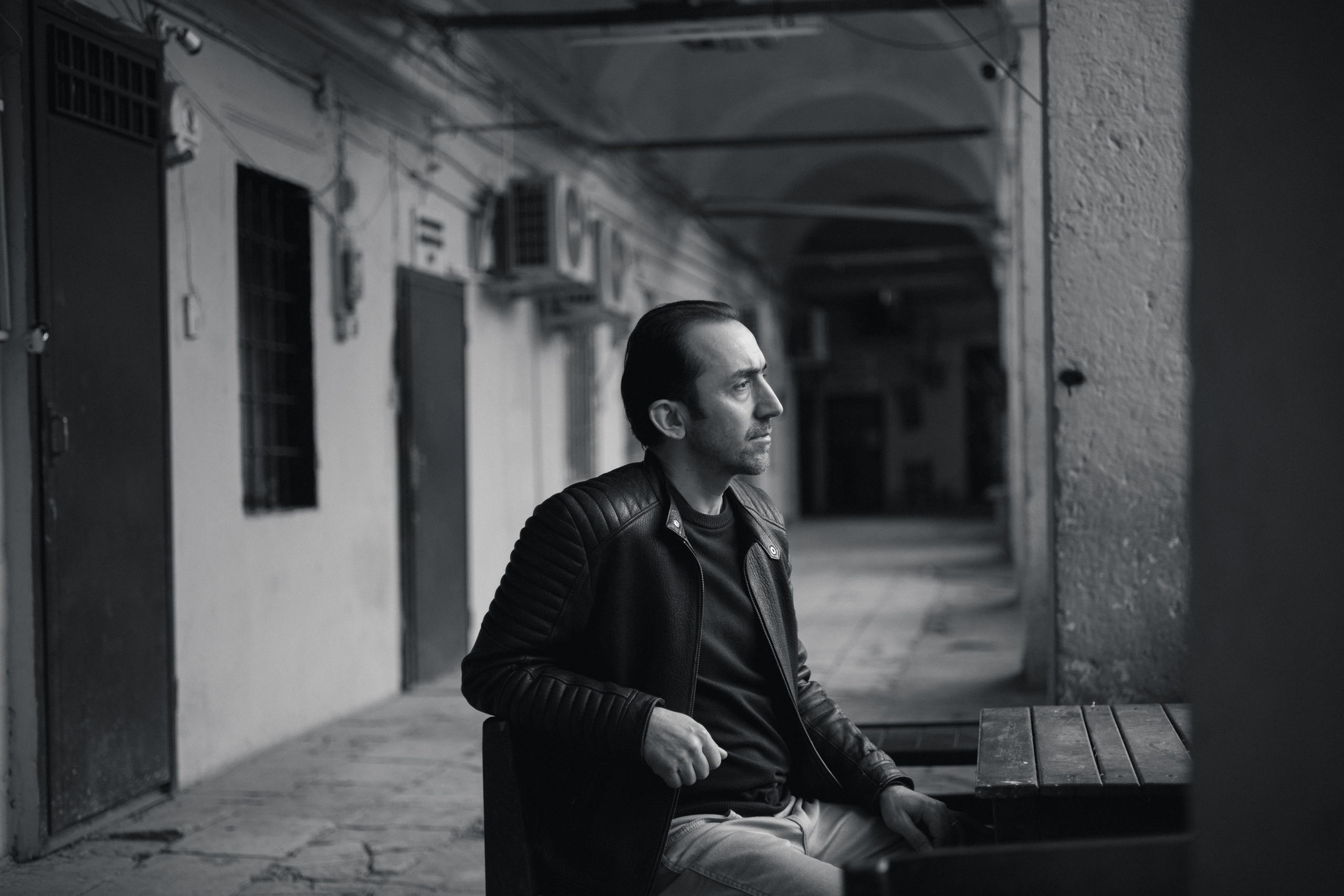 Мужской портрет в Стамбуле в старинной аркаде, мужчина в кожаной куртке за столом